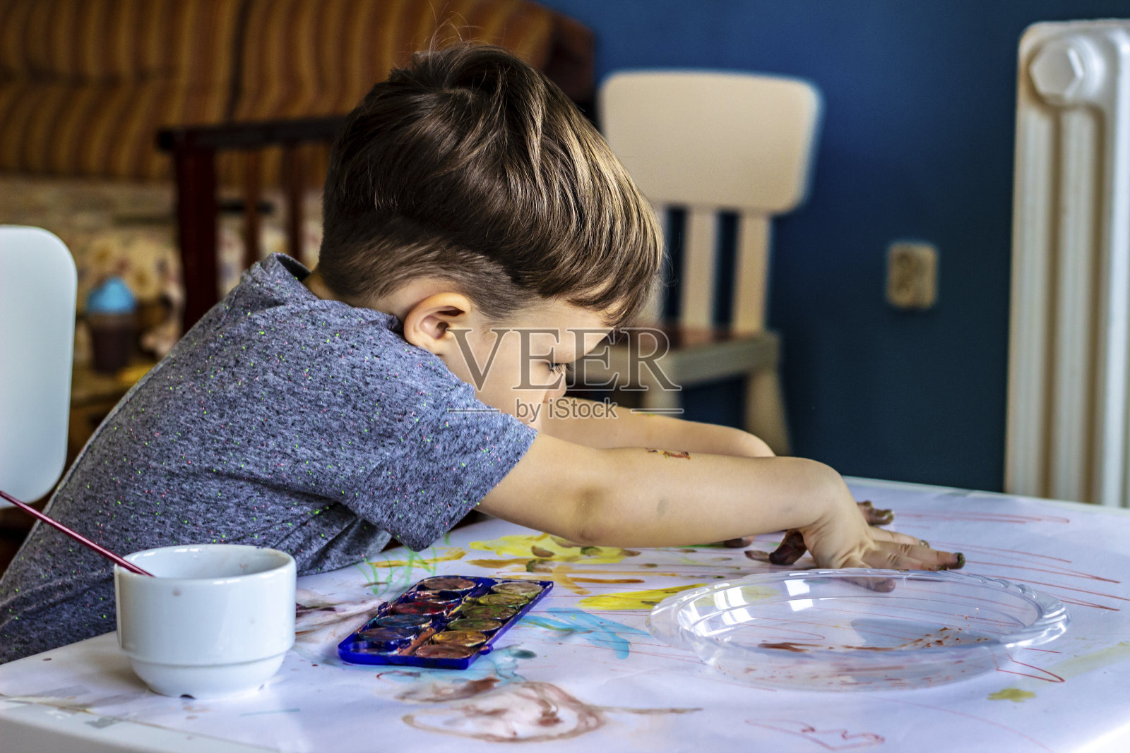 漂亮的男孩在白色背景上制作手印。照片摄影图片