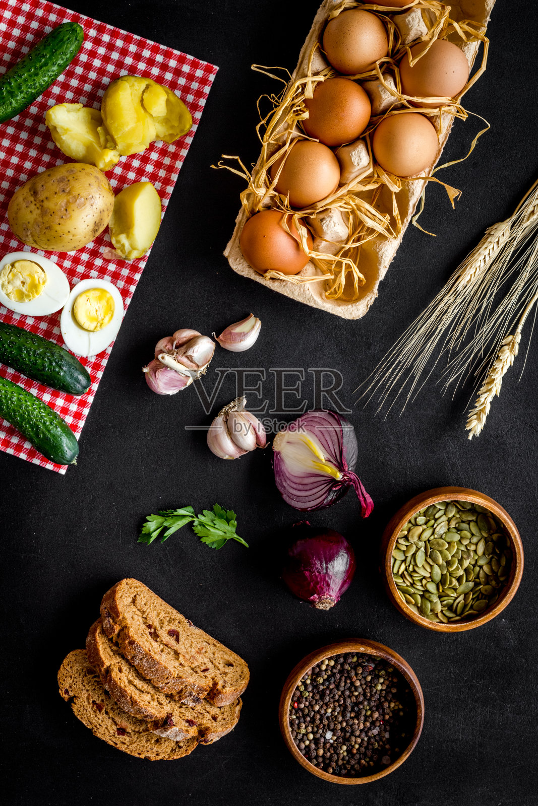 餐桌上有新鲜的自制食物——鸡蛋、面包、土豆。俯视照片摄影图片