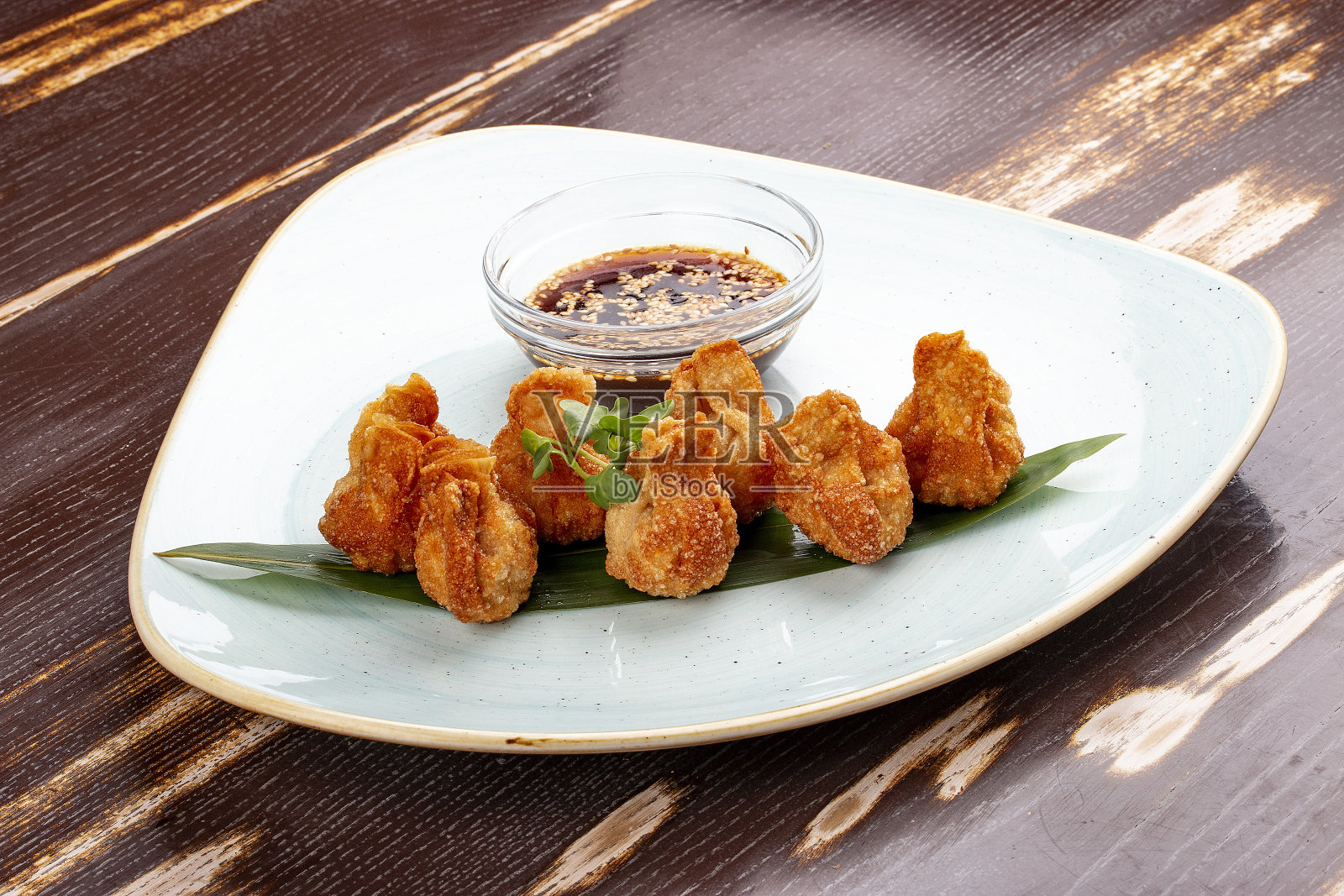 用竹叶蘸酱油炸馄饨。照片摄影图片