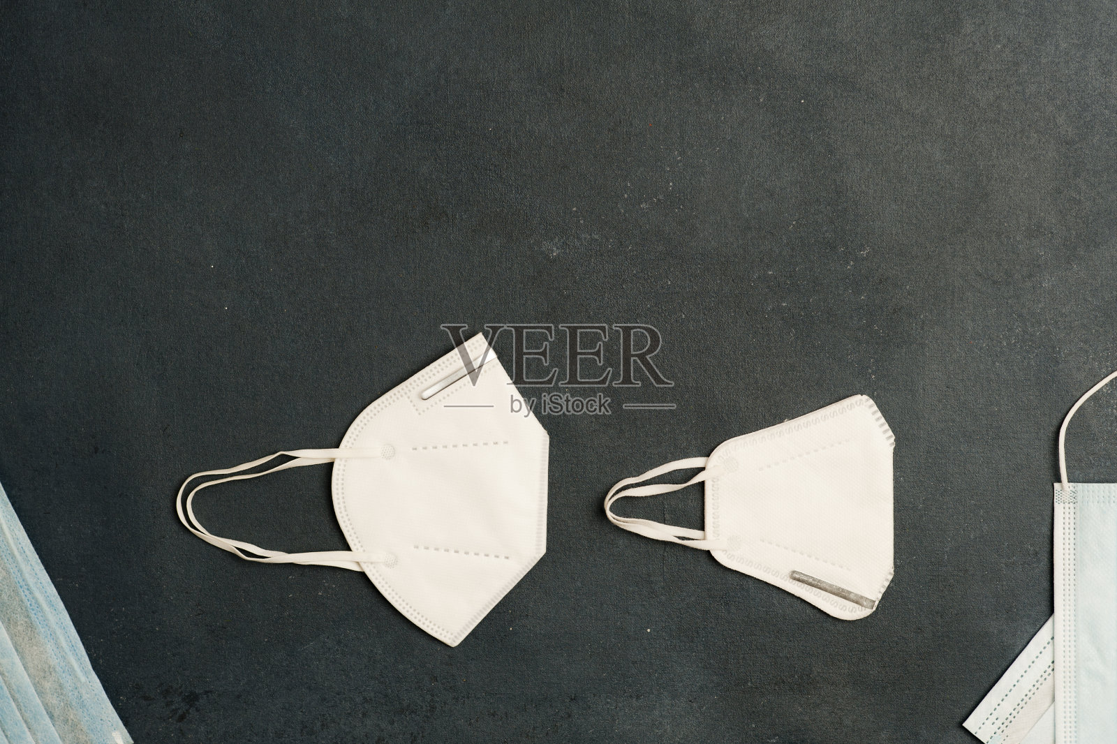 COVID-19概念，不同类型的口罩，灰色背景。俯视图照片摄影图片