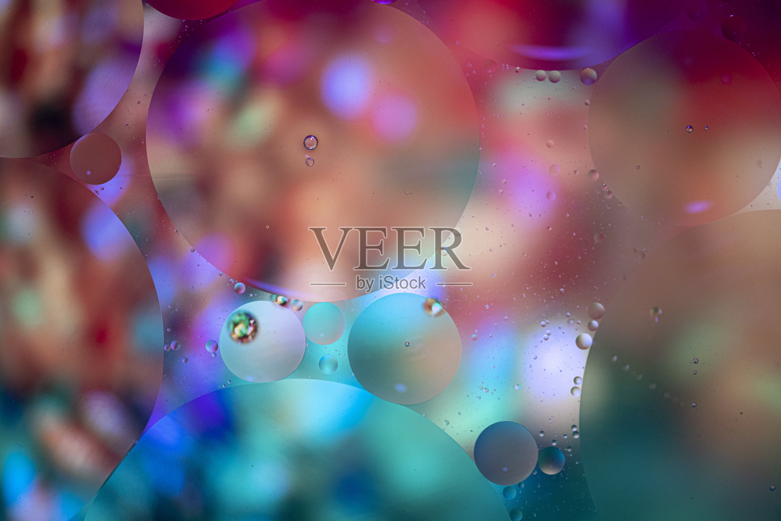 抽象背景与鲜明的颜色。油滴在水里。关闭多彩的艺术泡泡。空间模式。照片摄影图片