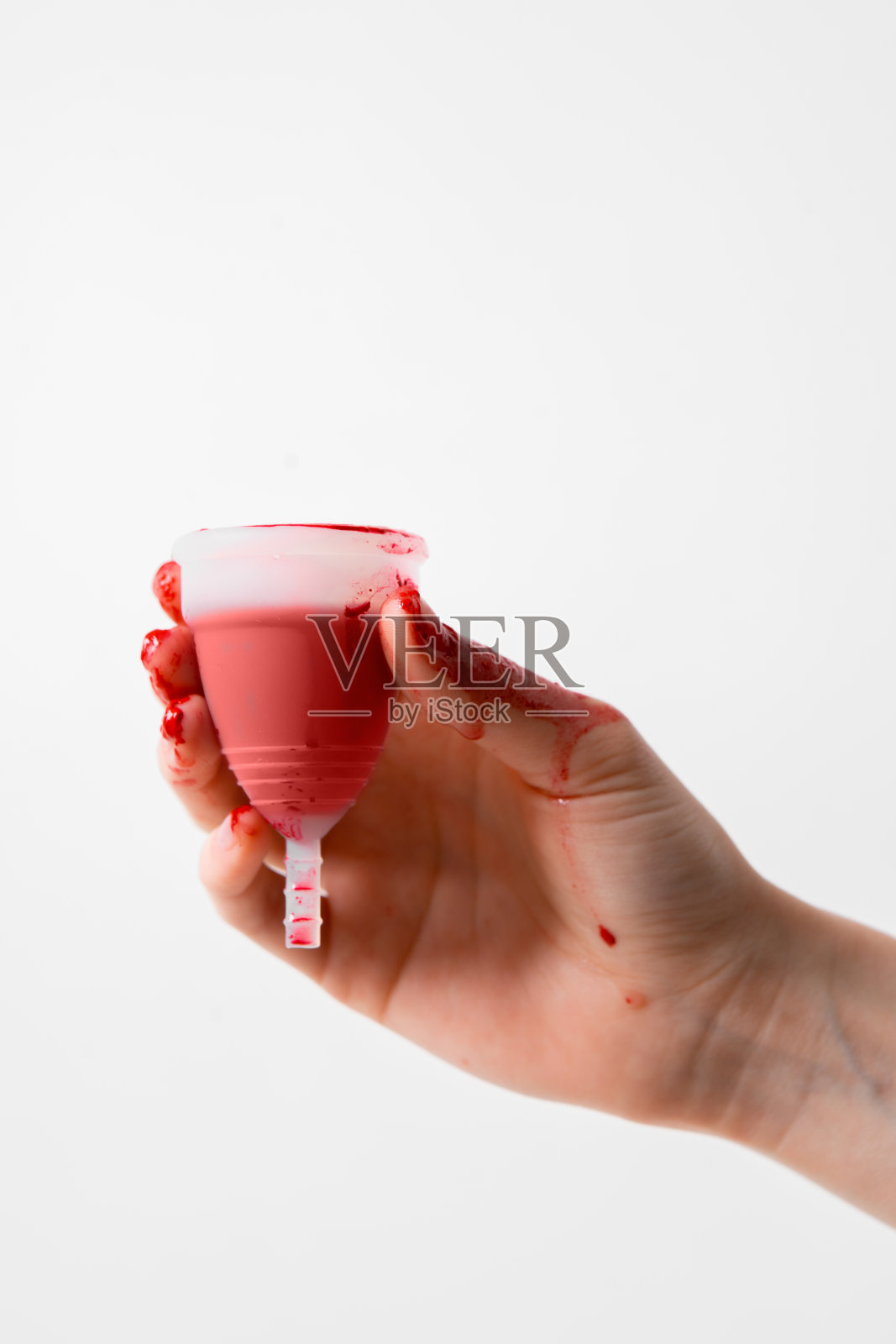 月经杯环保可重复使用，硅胶在妇女的手上，月经液隔离在一个白色的背景照片摄影图片