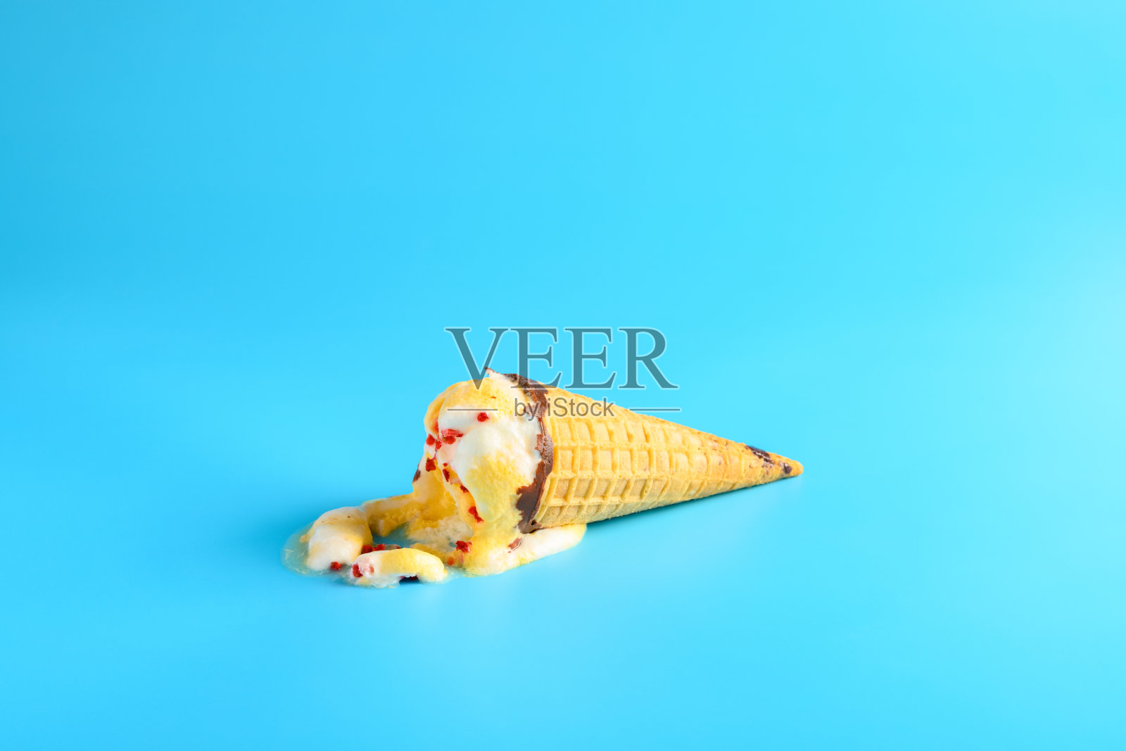 蓝色背景上融化的菠萝和樱桃味冰淇淋蛋卷照片摄影图片