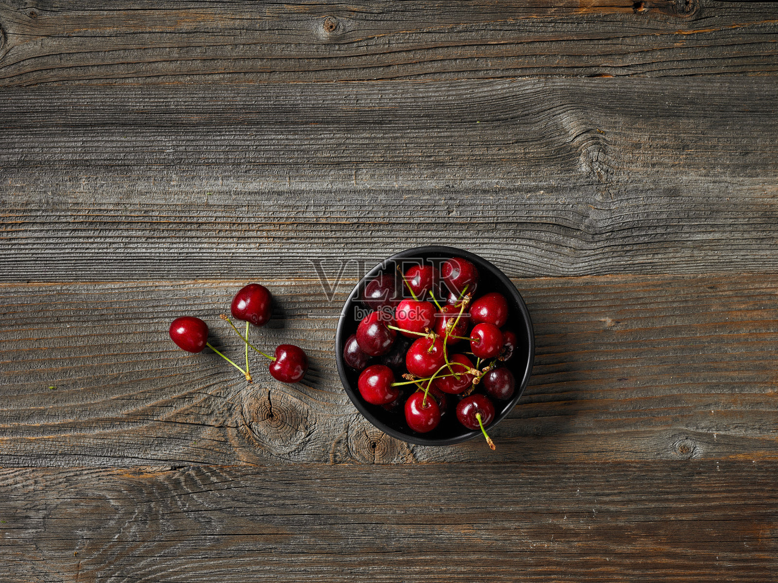 乡村餐桌上放着一碗新鲜的生樱桃照片摄影图片