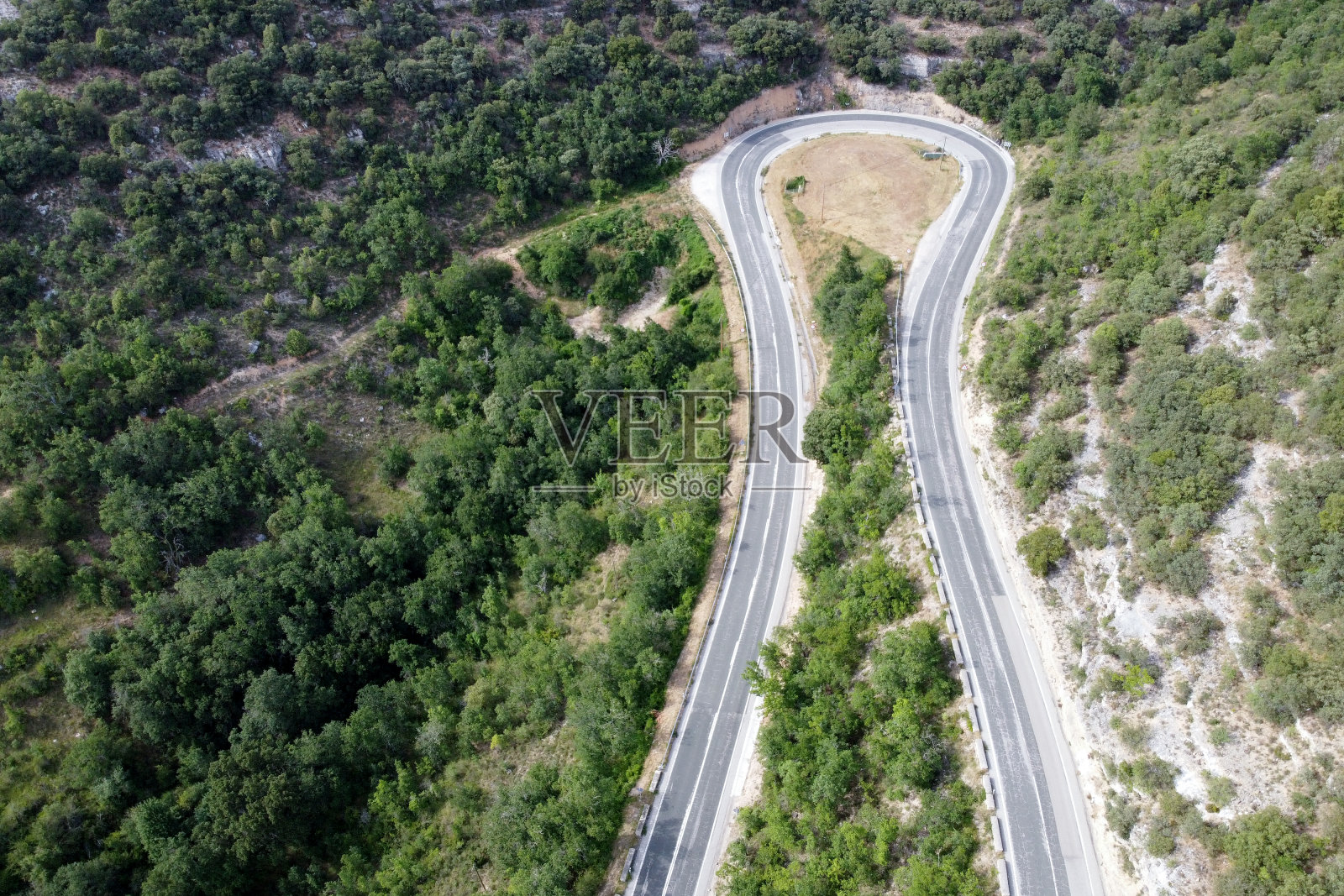 鸟瞰图蜿蜒的道路在高山口槽绿色松林。高质量的照片照片摄影图片
