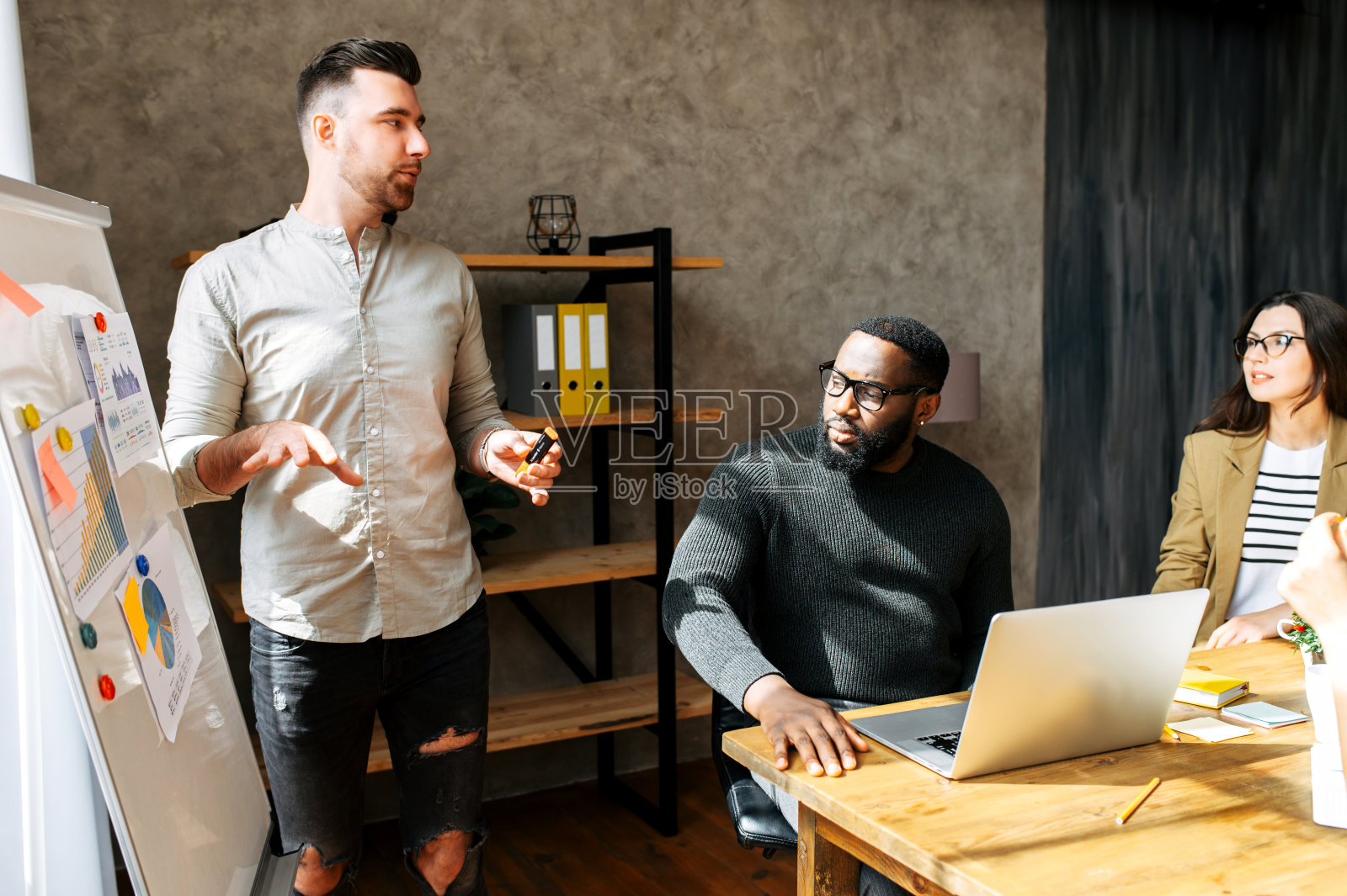 在办公室的一个多种族团队中展示照片摄影图片