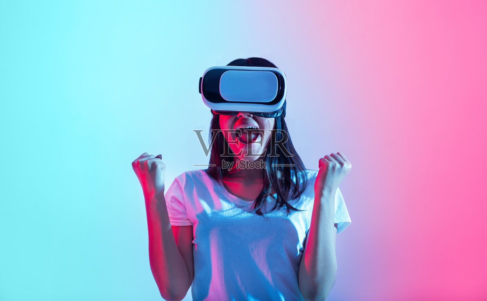 令人惊奇的情感和在比赛中获胜。戴着霓虹灯虚拟眼镜的快乐女孩照片摄影图片