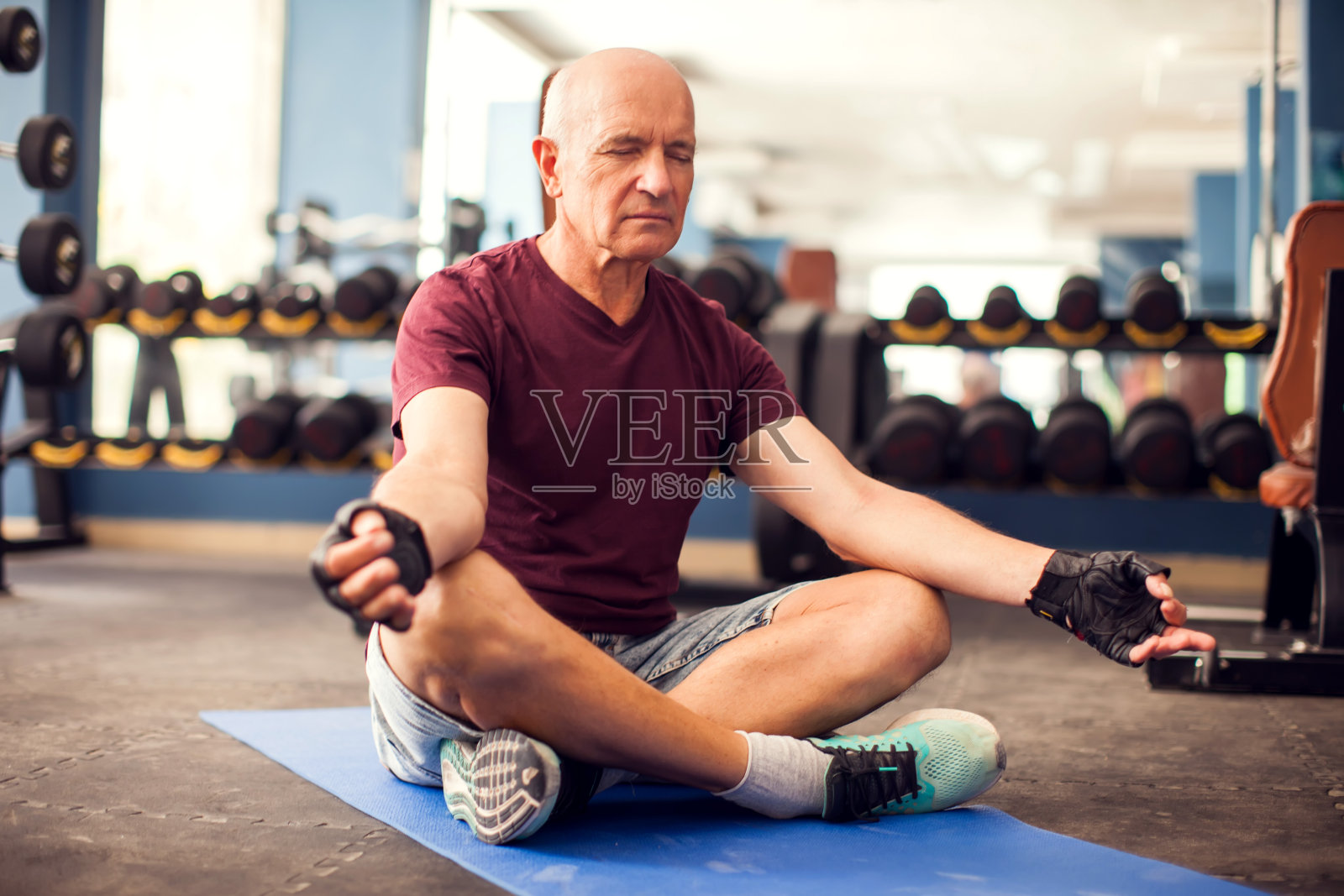 一幅老年人在健身房做放松运动的肖像。人、保健和生活方式的概念照片摄影图片