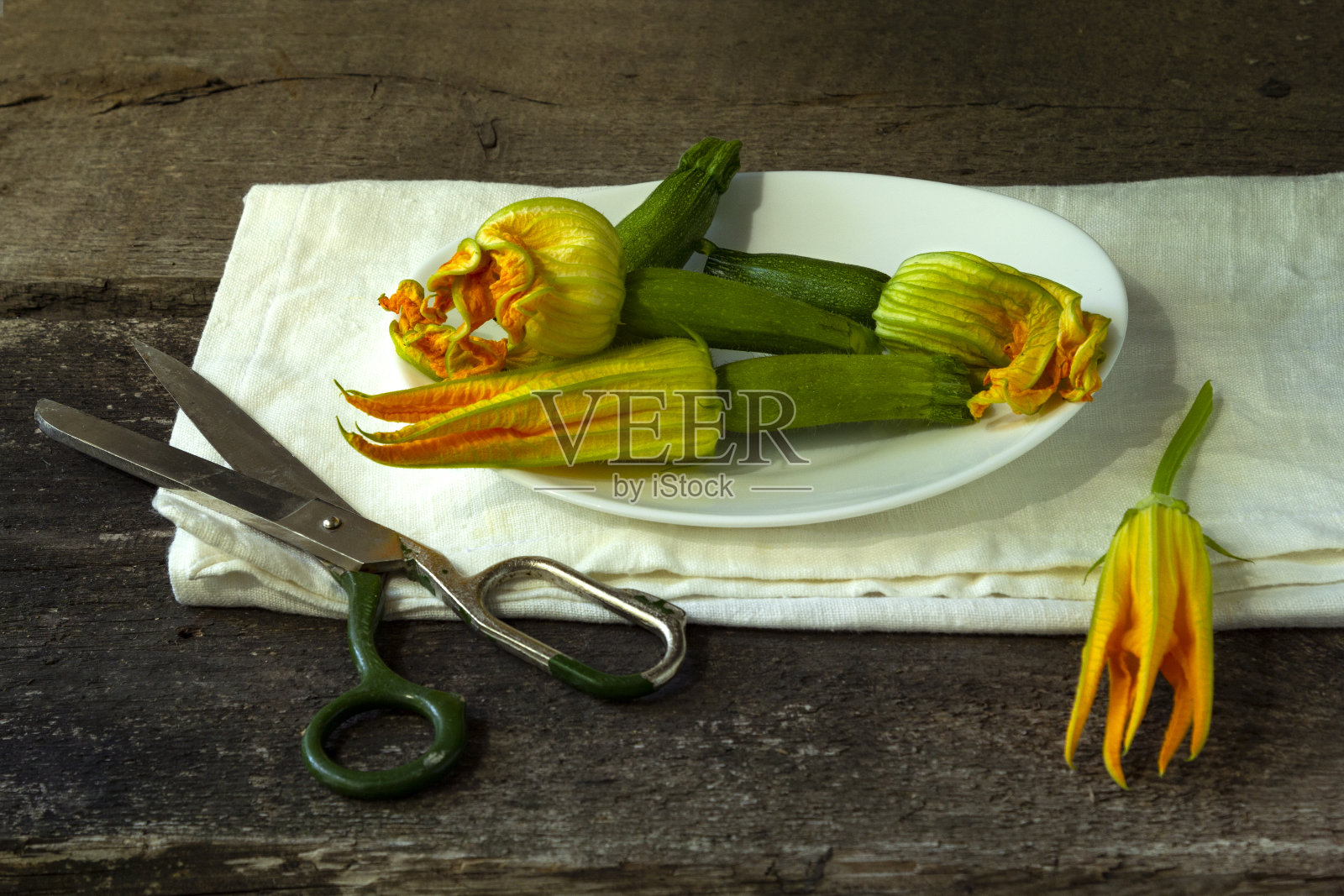 旧木桌上放着西葫芦花照片摄影图片