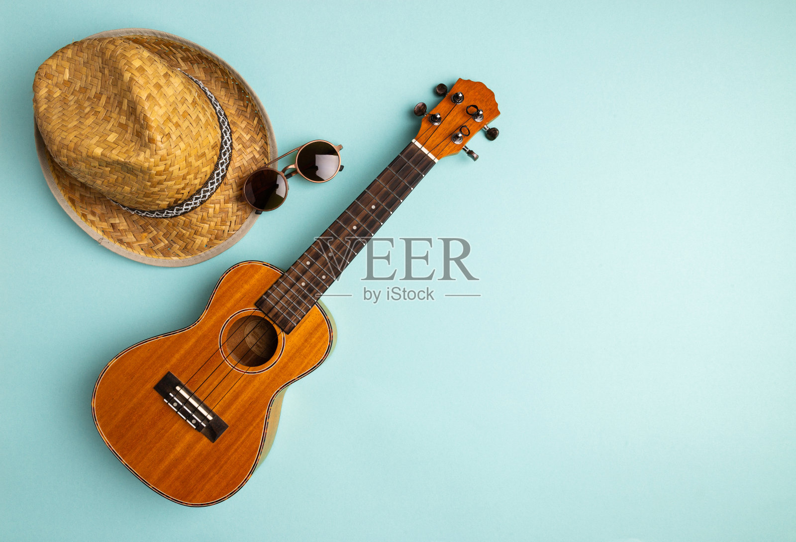 夏季度假概念与四弦琴和草帽在抽象蜡笔绿松石背景与复制空间照片摄影图片