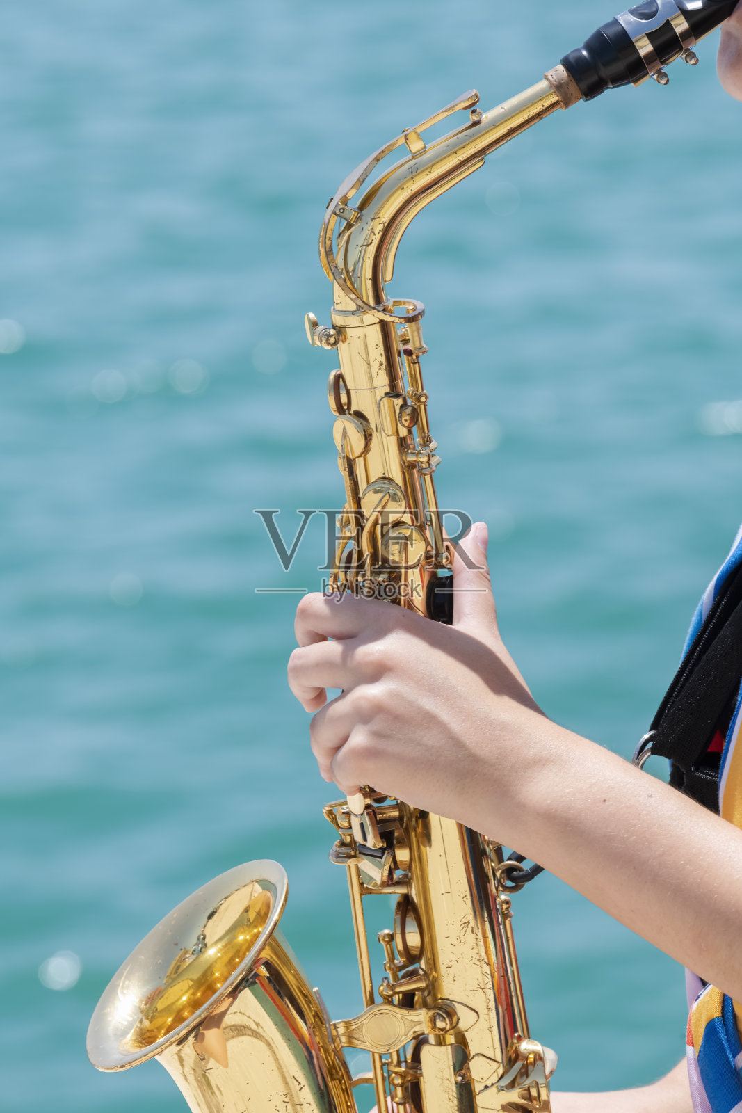 一个女人拿着一个闪闪发光的金色萨克斯管演奏照片摄影图片