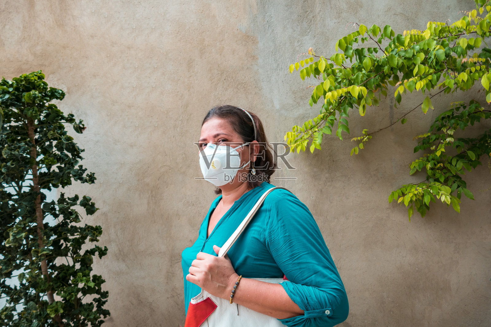 因新冠肺炎疫情而关闭的沙漠公园中戴着防护口罩的老年女性。周围没有人照片摄影图片