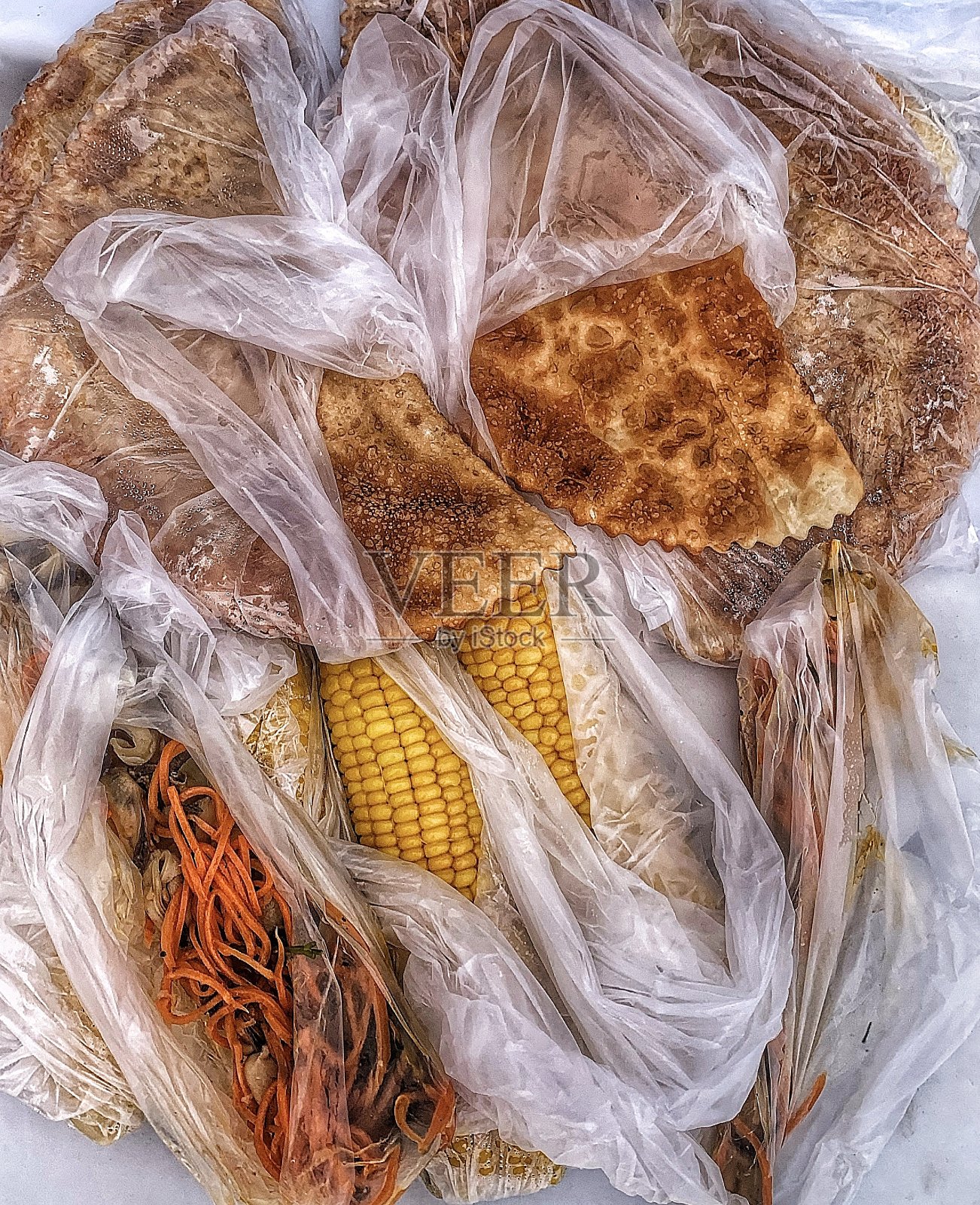 玉米，辣胡萝卜，还有塑料袋里的炸面包卷照片摄影图片