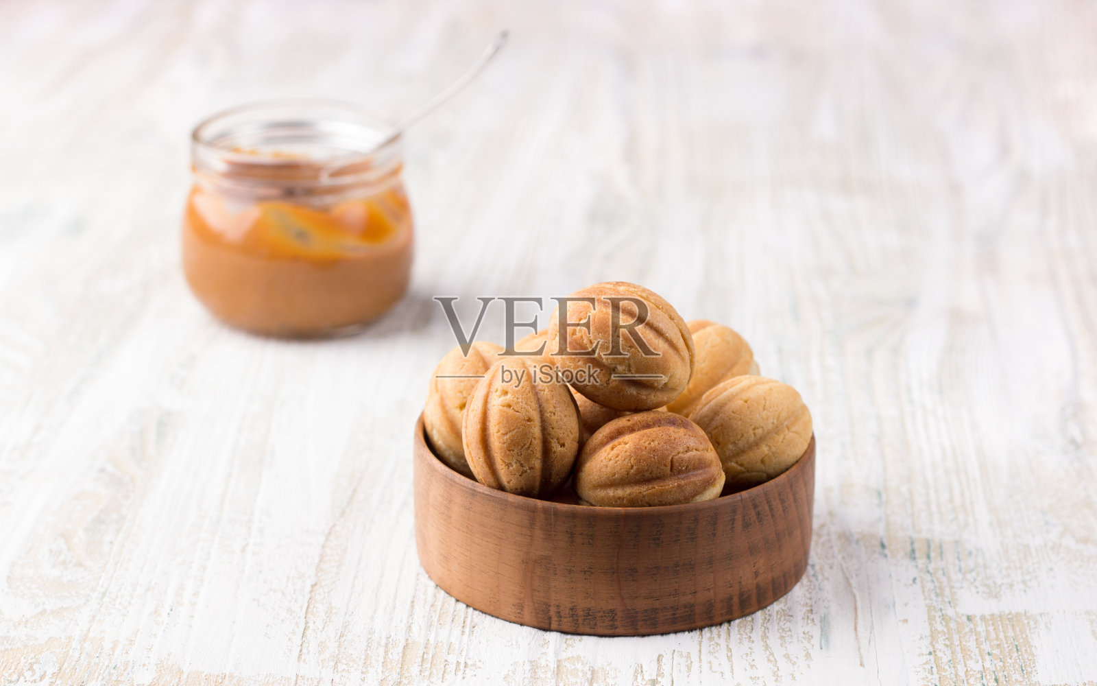 传统的俄罗斯自制甜糕点，松脆坚果和煮炼乳在木碗木背景照片摄影图片