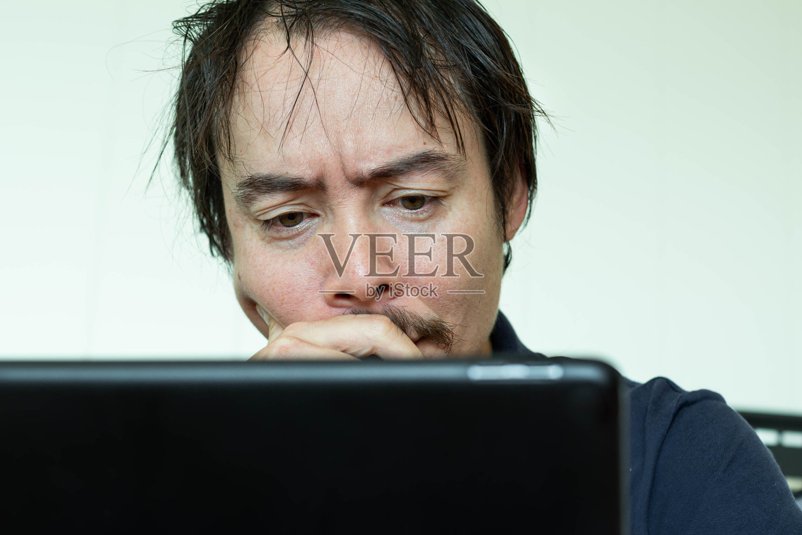 盯着电脑的焦虑男人，有经济问题照片摄影图片