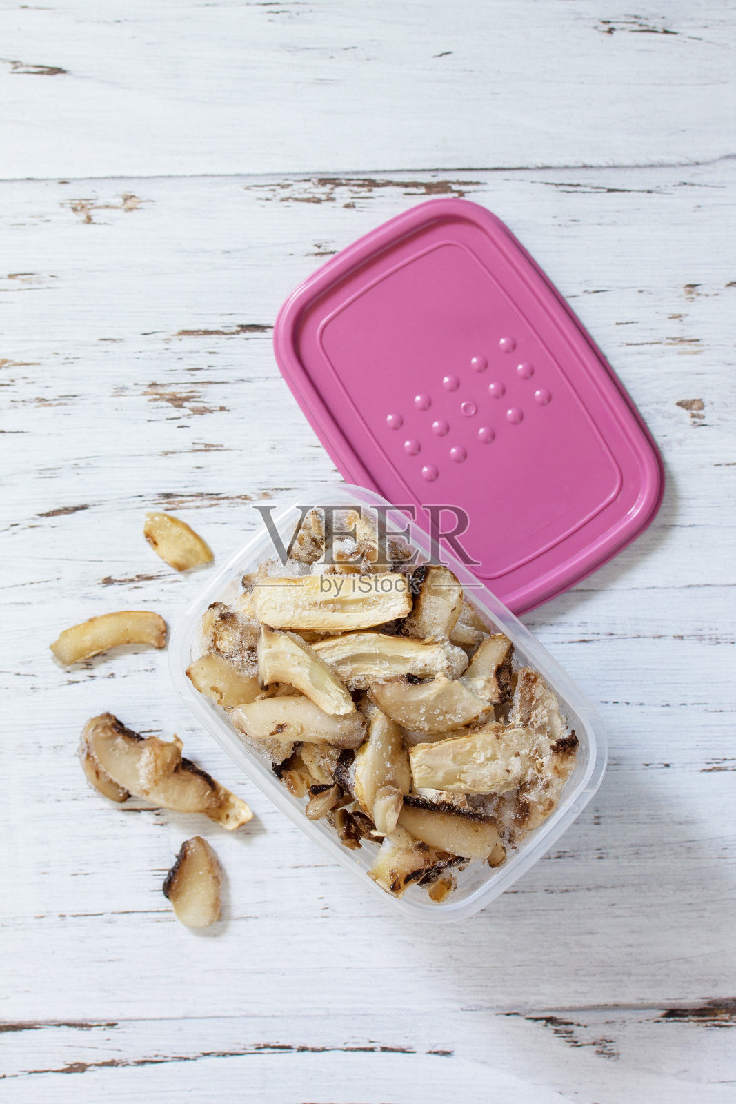 冬天的食物。冷冻蔬菜。装冷冻蘑菇的容器。俯视图平铺背景。照片摄影图片