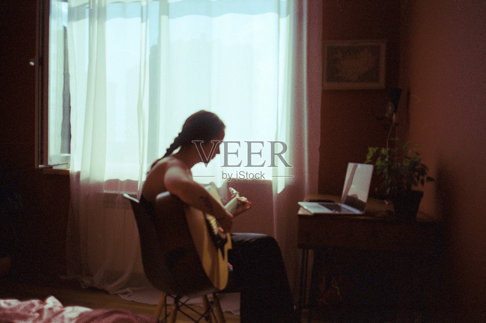 一个女人在公寓里弹吉他照片摄影图片