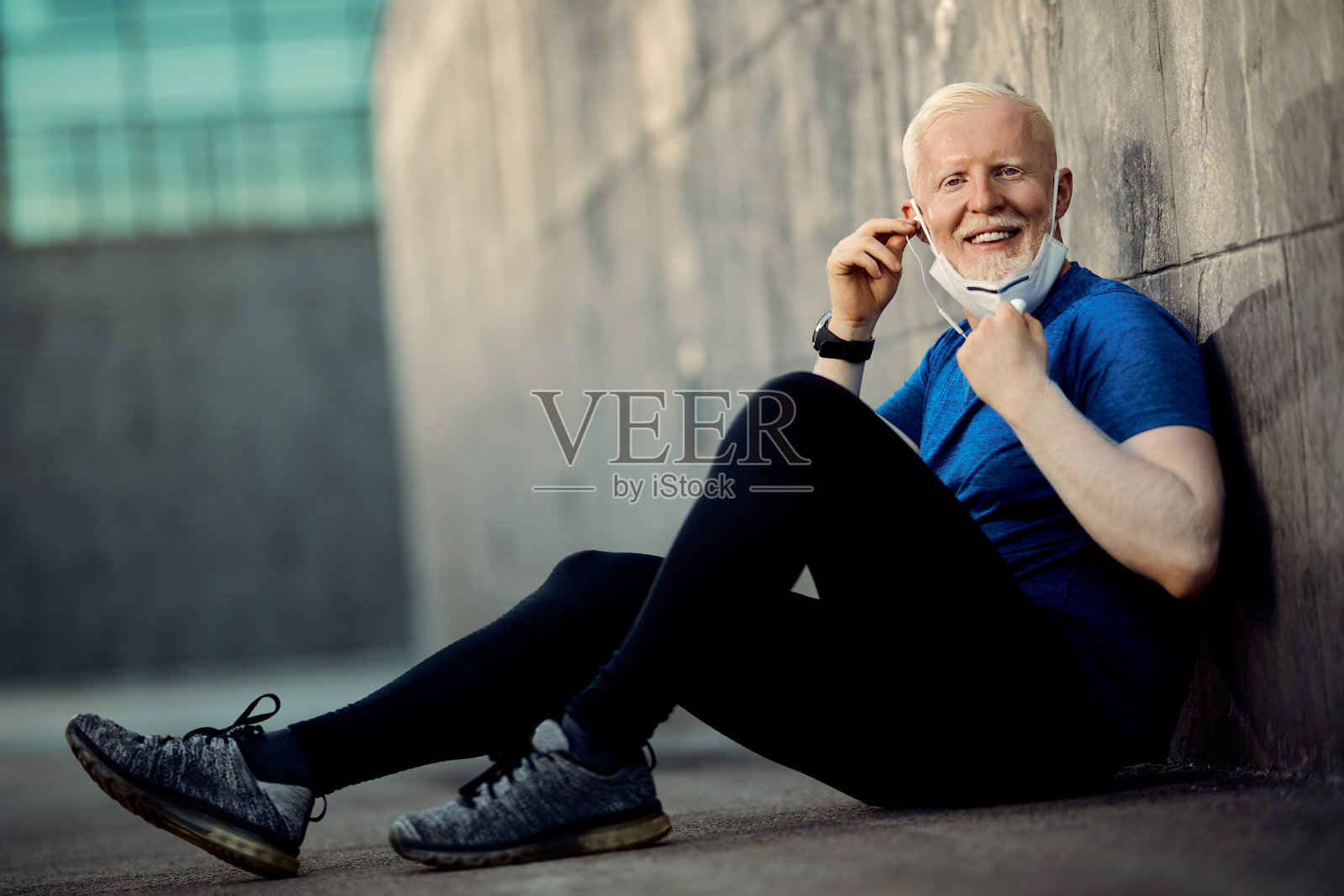 快乐的白化病运动员带着口罩，在户外运动后放松。照片摄影图片