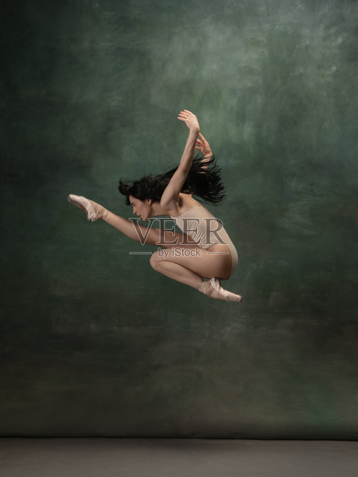 年轻优雅温柔的芭蕾舞女演员在深绿色的工作室背景照片摄影图片