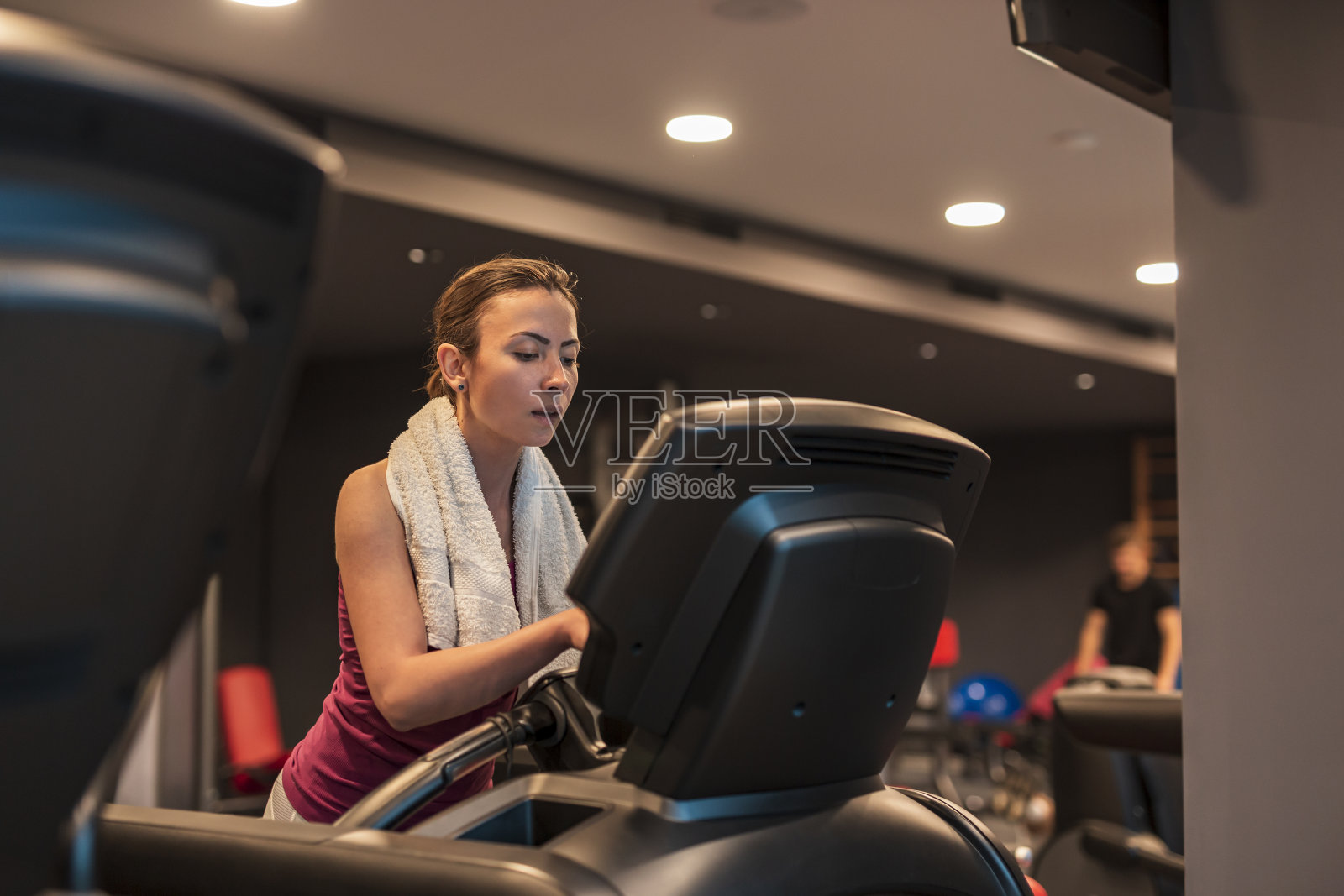 女人在健身房锻炼，在跑步机上慢跑照片摄影图片