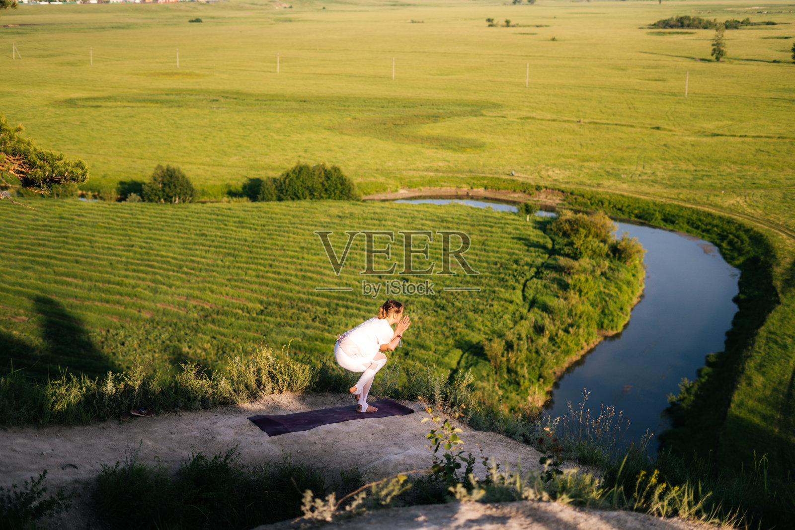年轻放松的女子练习瑜伽，站在鹰操，鹰式体式。照片摄影图片