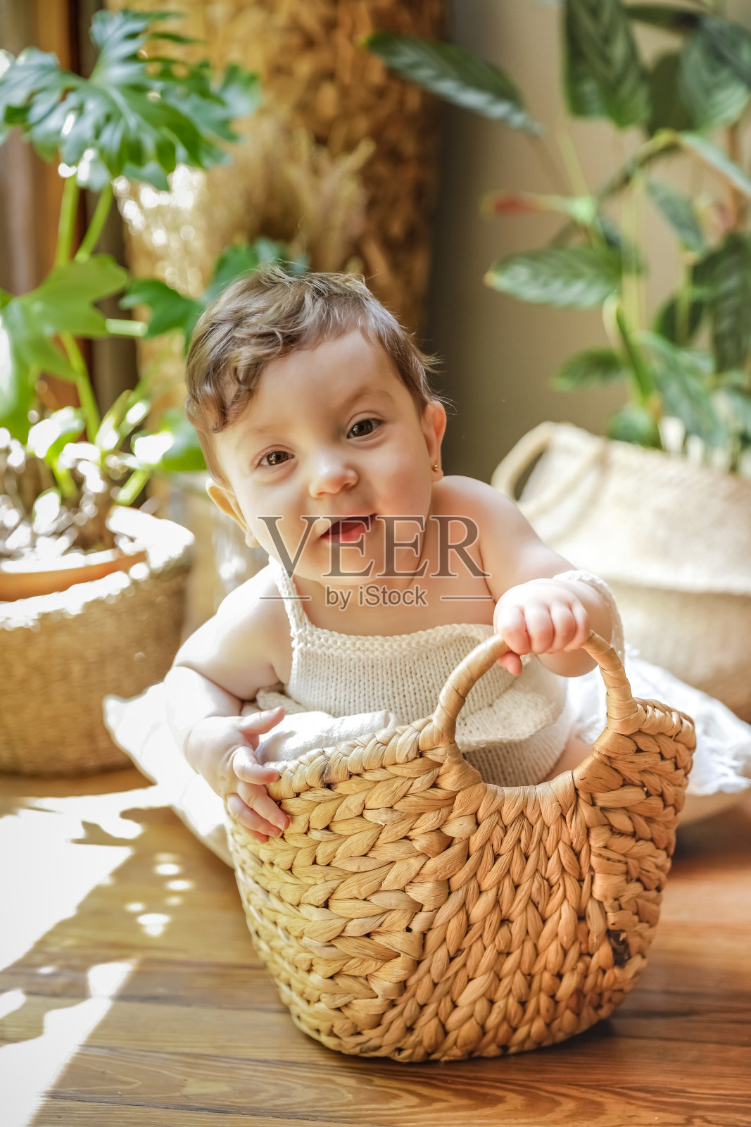 一个一岁的婴儿微笑着在篮子里摆姿势照片摄影图片