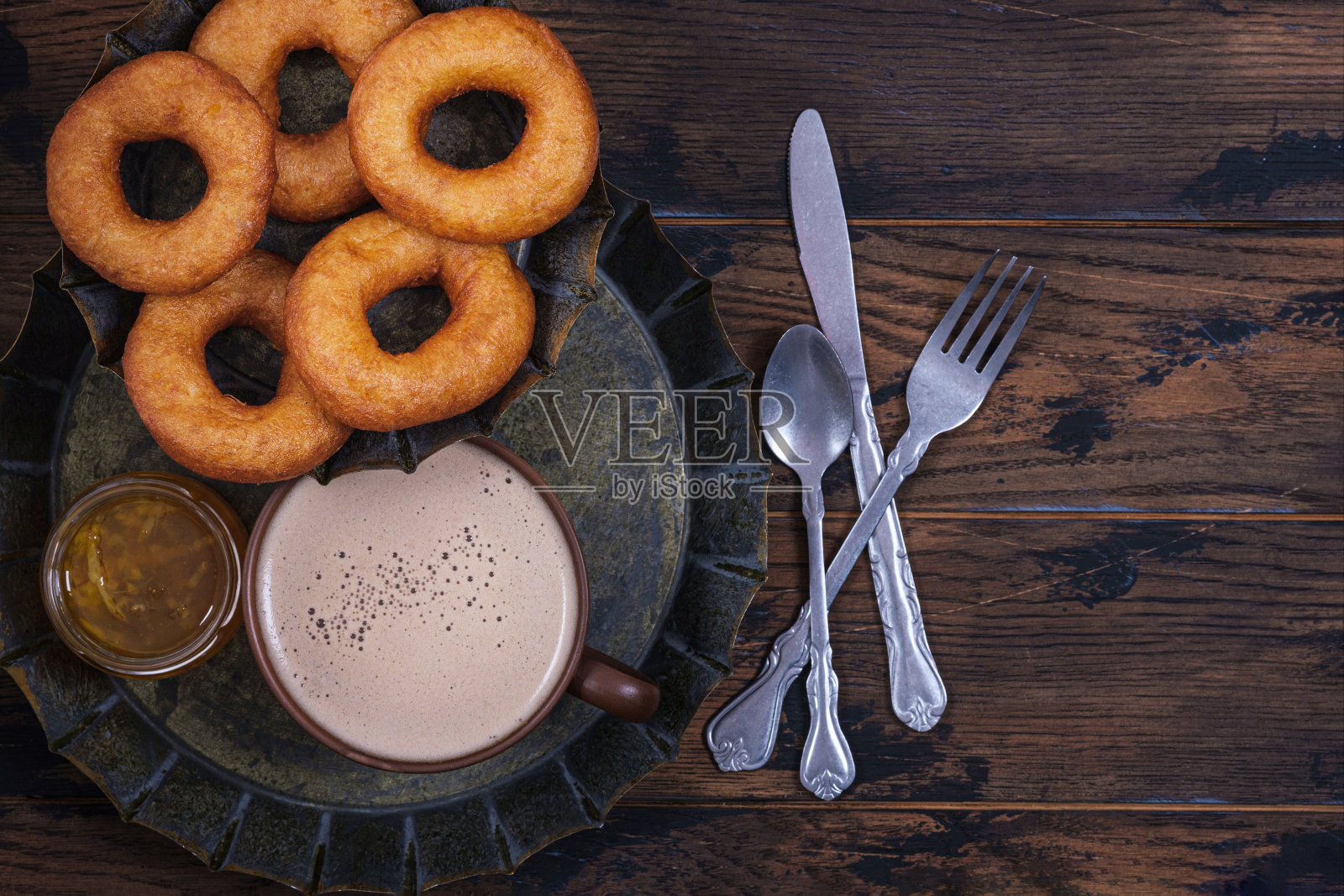 木桌上放着甜甜圈、果酱和咖啡杯照片摄影图片