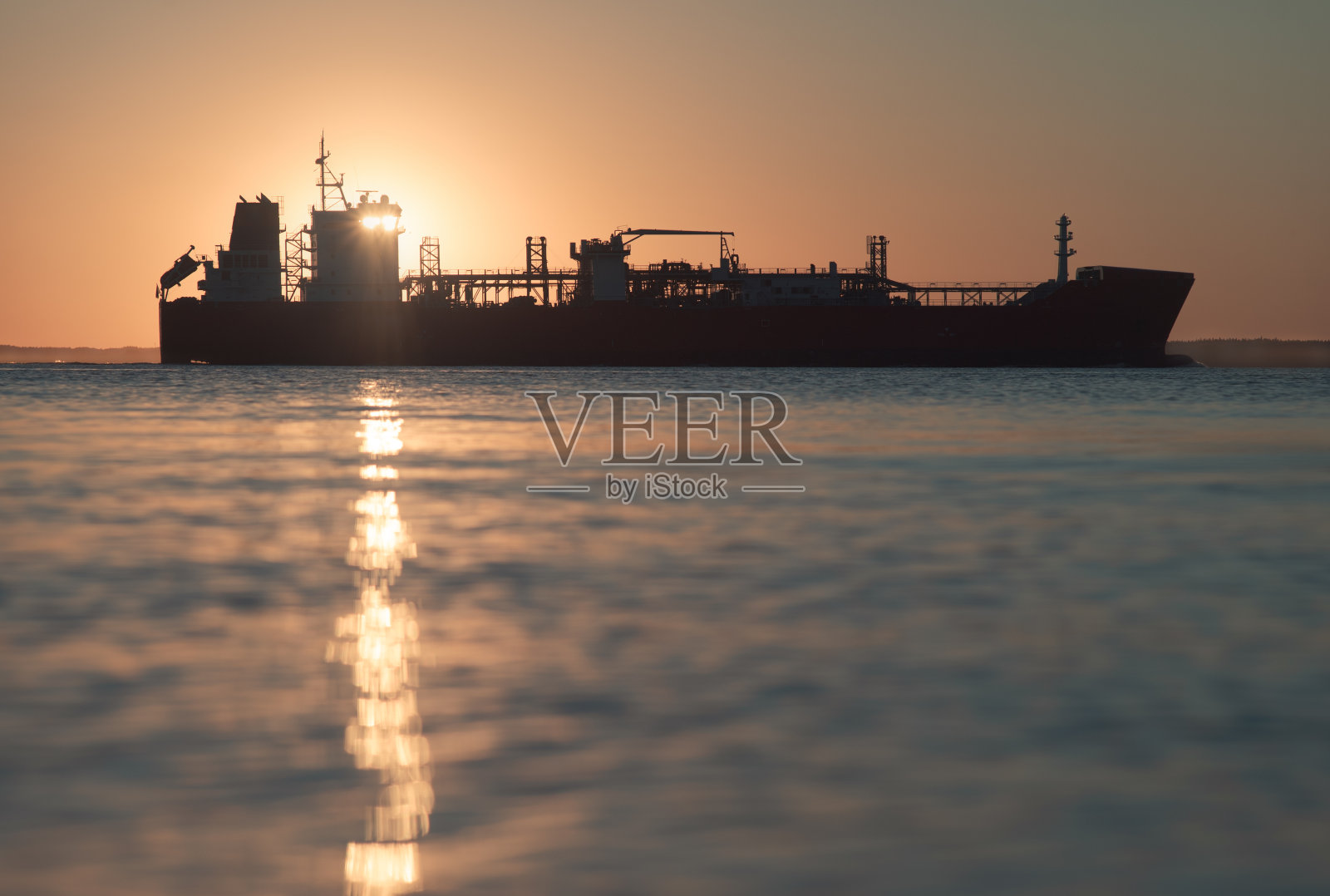 运输液化天然气的船。侧视图。背景中的夕阳照片摄影图片