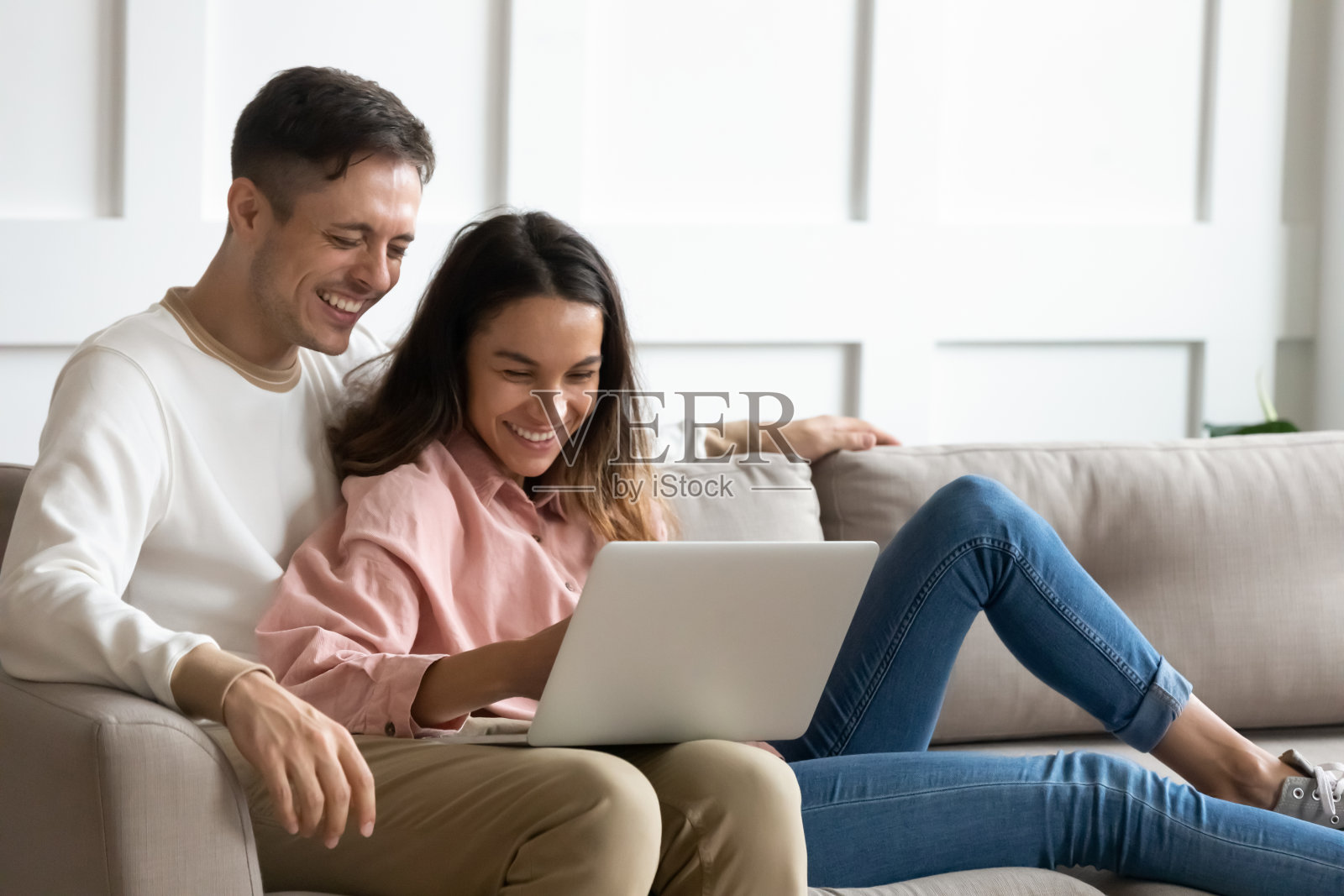 快乐的年轻夫妇一起使用笔记本电脑，在周末玩得很开心照片摄影图片