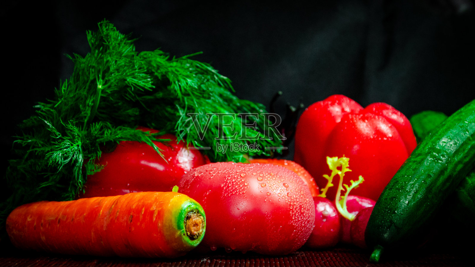 蔬菜，成熟的红番茄，甜椒，小茴香，萝卜，橙色，胡萝卜，黄瓜，在黑色背景的特写与水滴照片摄影图片