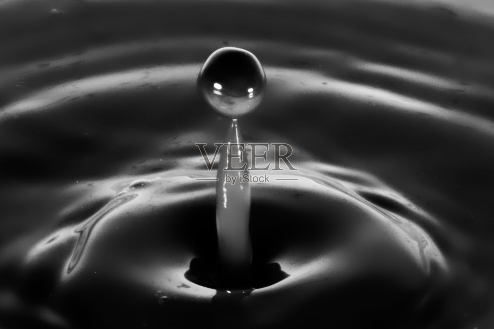 近距离观察水滴坠落并撞击水体照片摄影图片