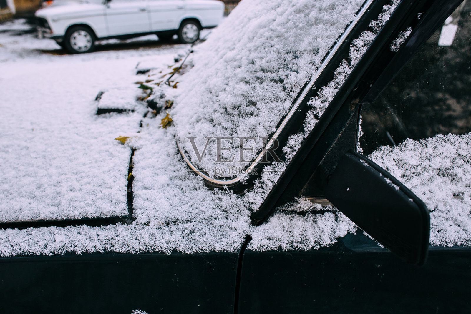 一场又一场的雪落在汽车上。冬天的城市风光。照片摄影图片