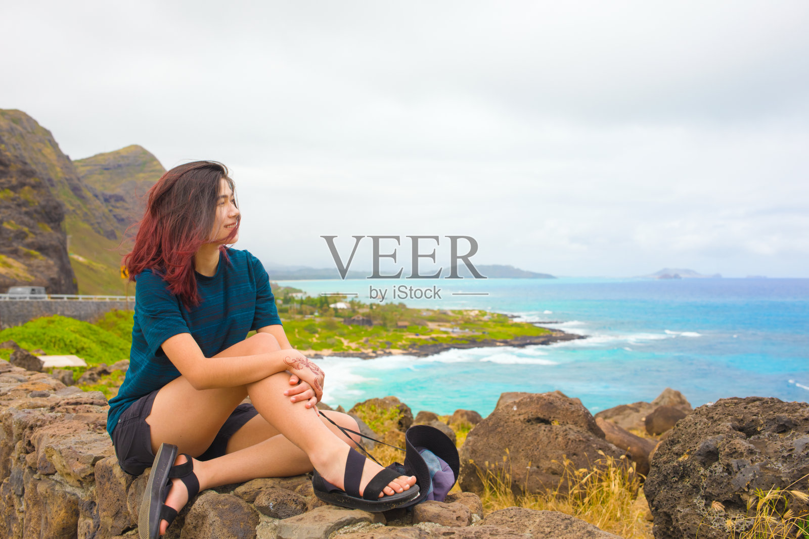 少女坐在岩石上俯瞰夏威夷瓦胡岛马卡普乌海滩照片摄影图片