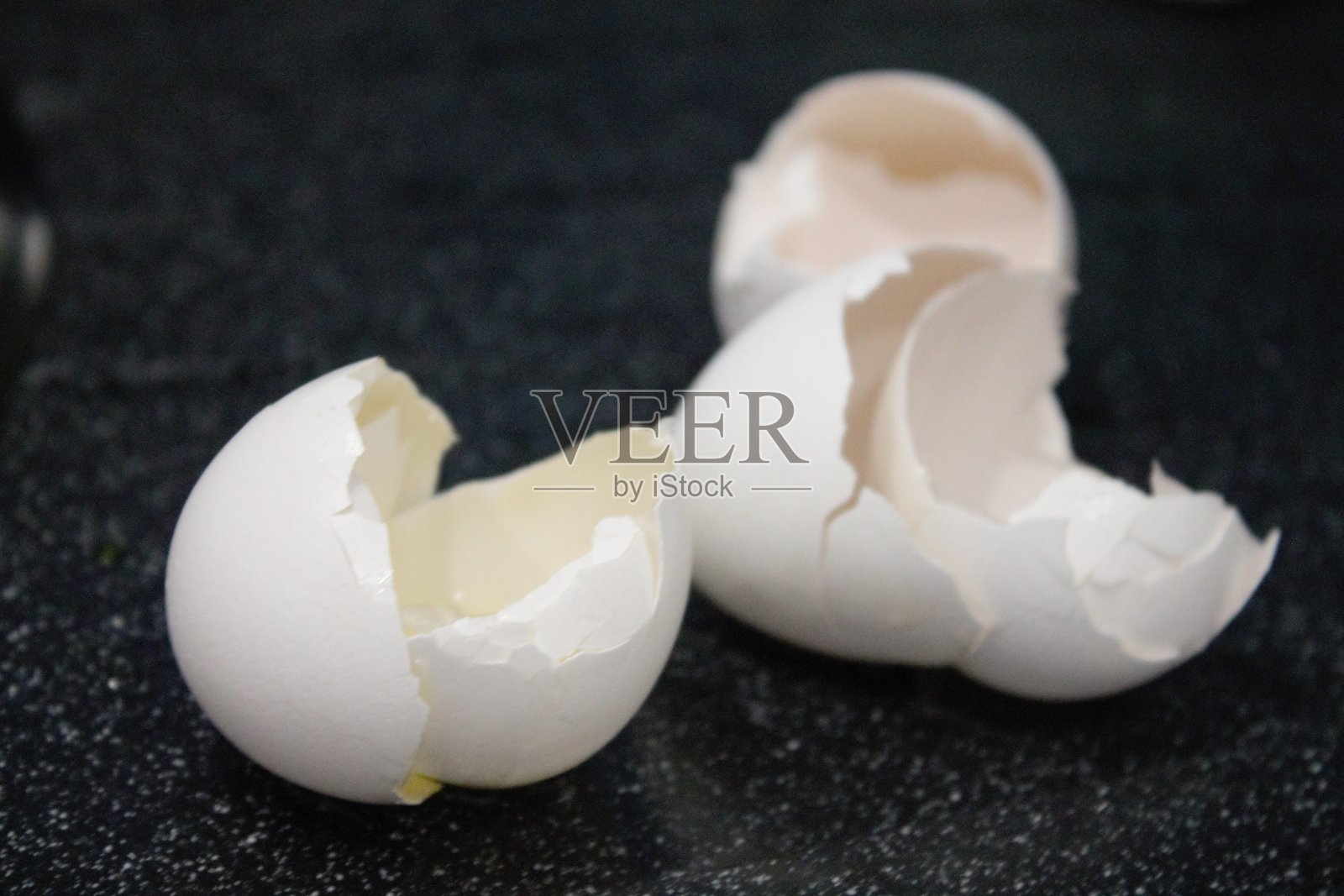 白色蛋壳上的黑色背景和白色飞溅照片摄影图片