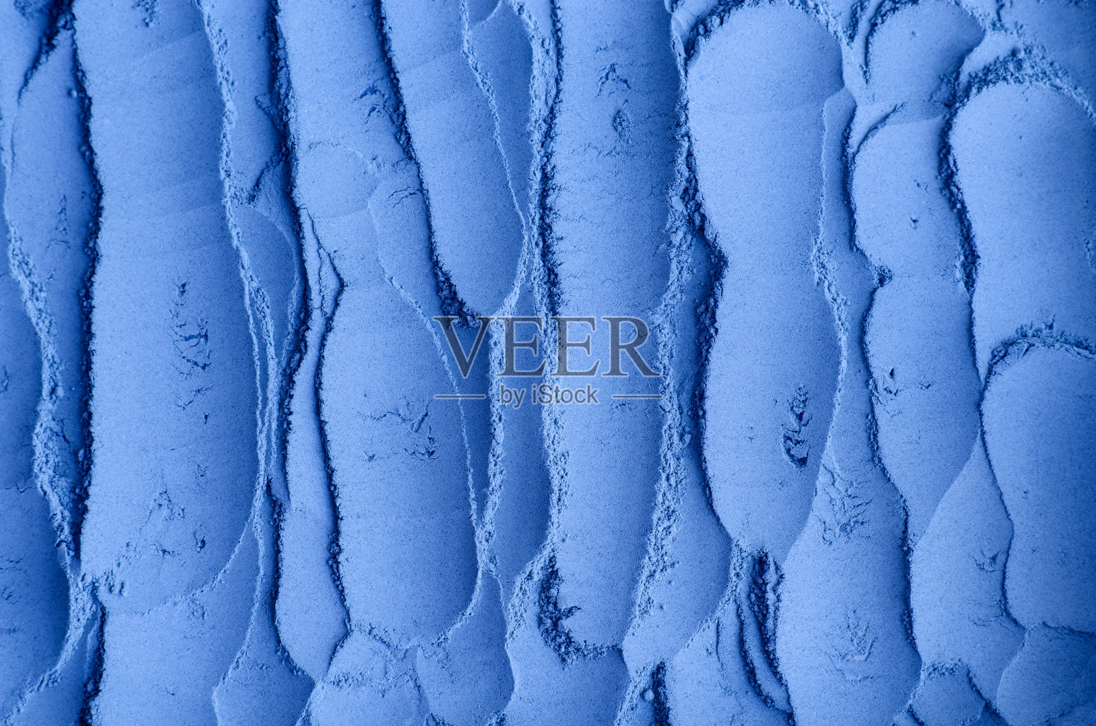 蓝色膨润土面膜泥粉(藻酸盐面膜、裹体)质地近距离，选择性聚焦。抽象的背景与画笔笔触。照片摄影图片