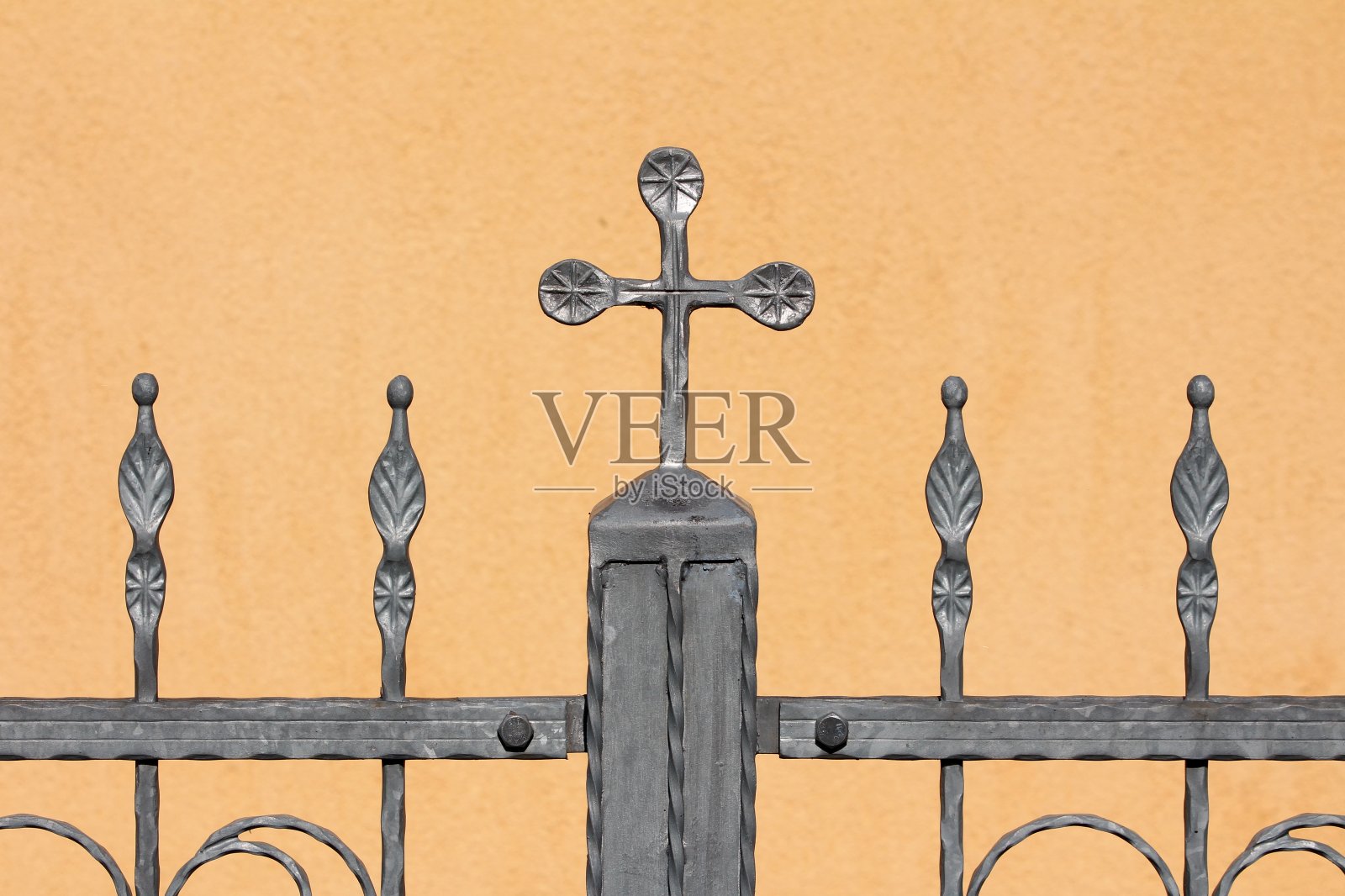 复古复古的灰色锻铁栅栏，上面有多个定制的小花大十字架形状的装饰照片摄影图片