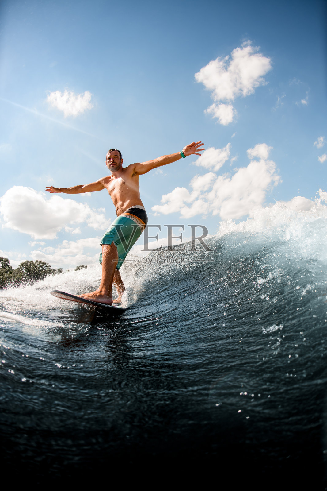 在冲浪板上的人正在积极地骑上海浪照片摄影图片