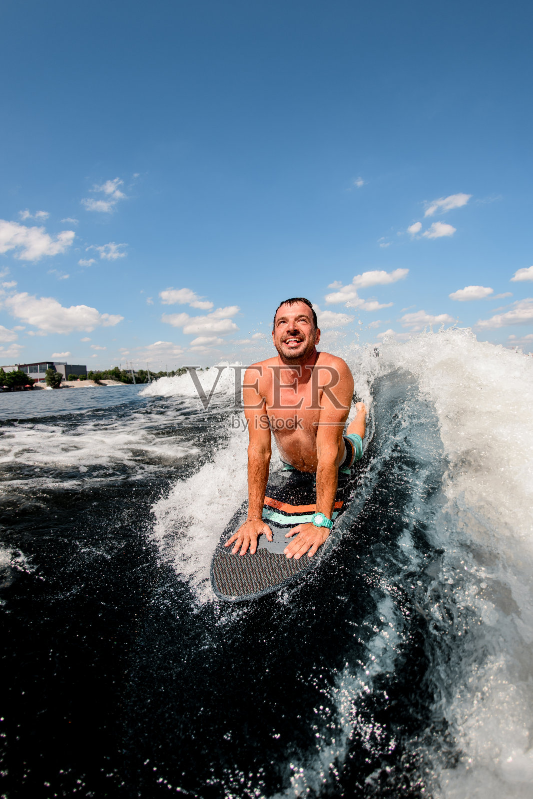 一个微笑的成年人躺在冲浪板上冲浪。照片摄影图片