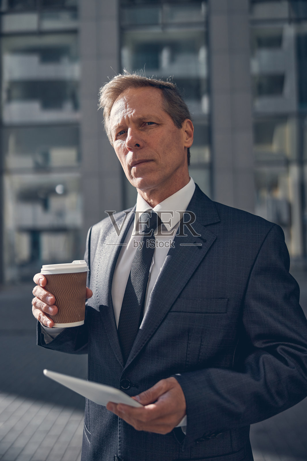 一个拿着平板电脑的帅哥站在街上照片摄影图片