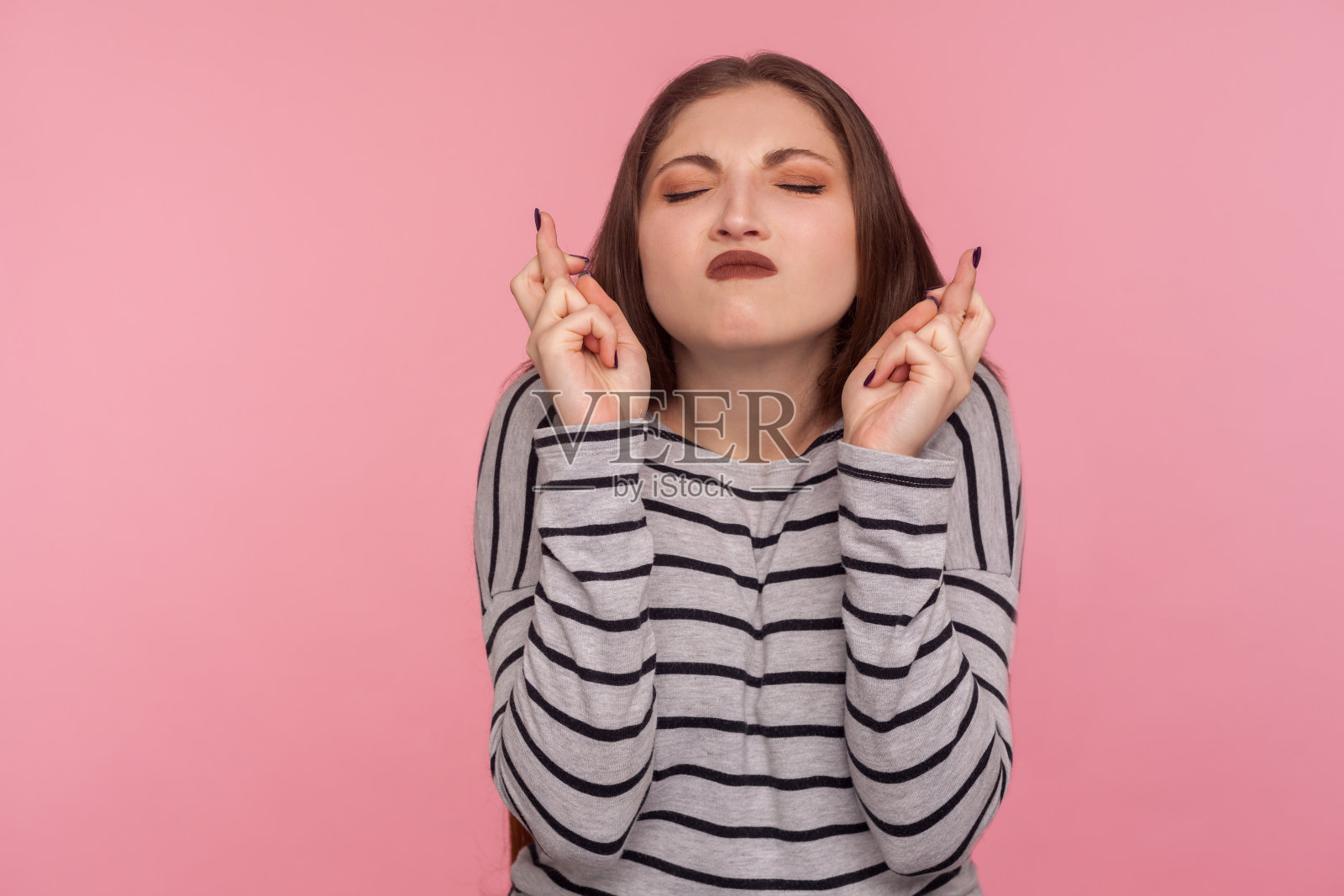 祝你好运!肖像的女人在条纹运动衫衷心许愿和保持手指交叉照片摄影图片