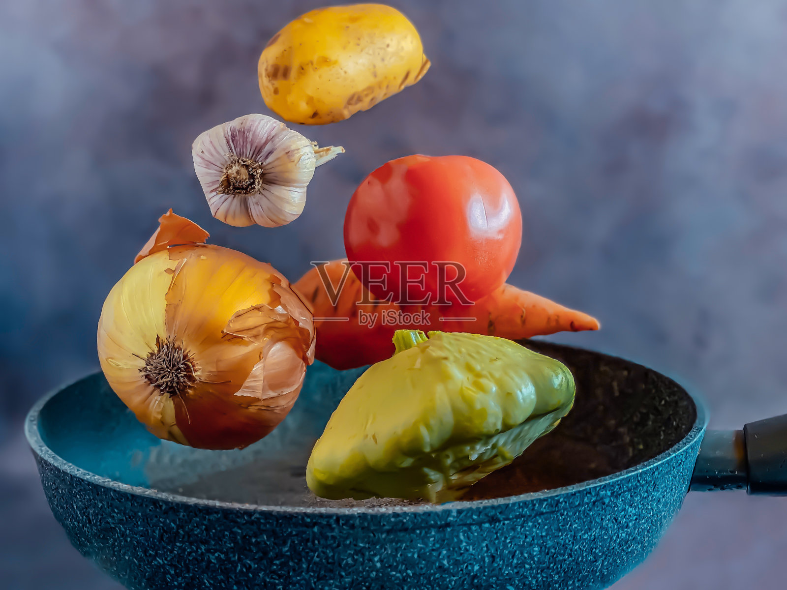 正在炖蔬菜的煎锅上漂浮的蔬菜。烹饪概念。照片摄影图片