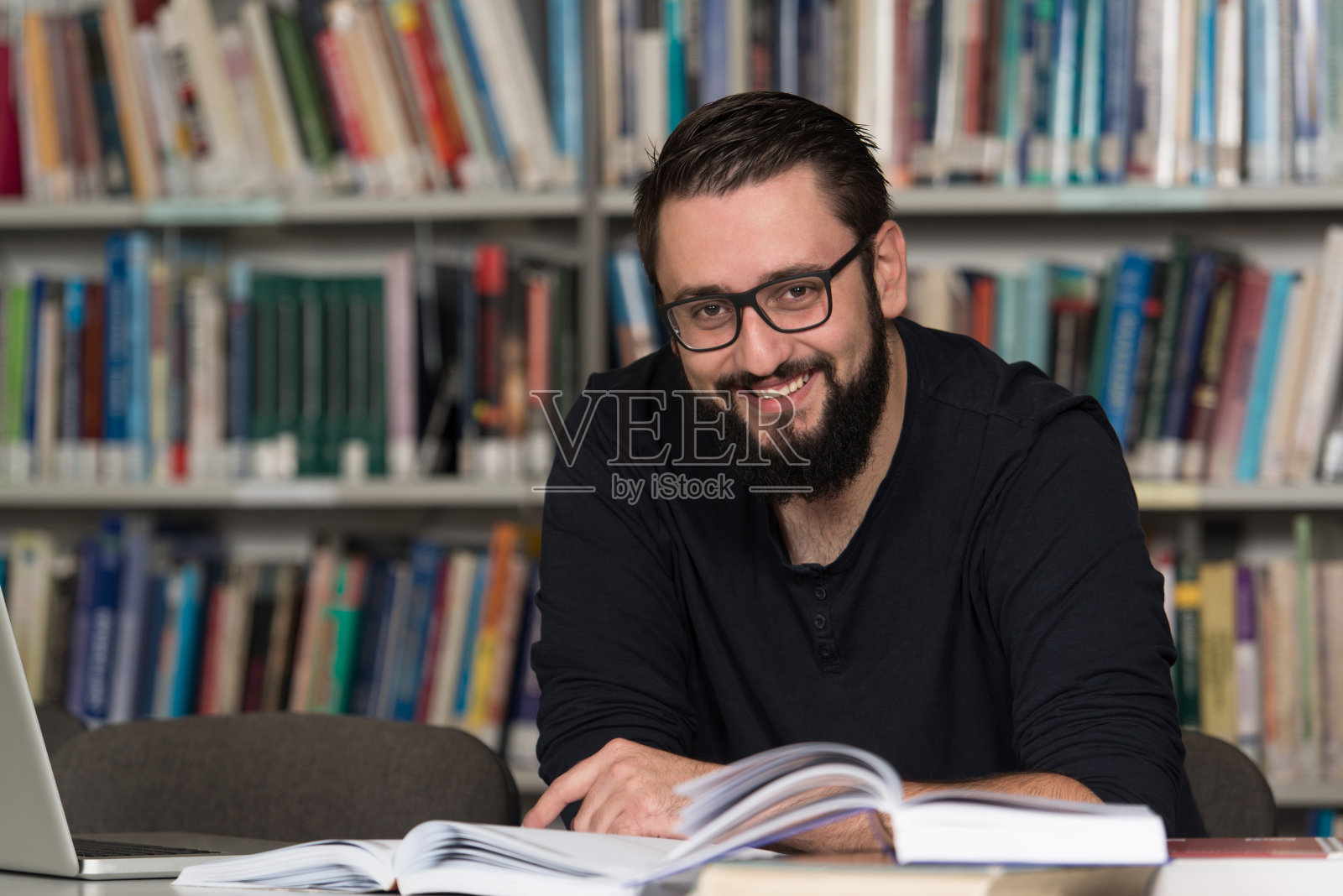 年轻的学生在图书馆使用他的笔记本电脑照片摄影图片