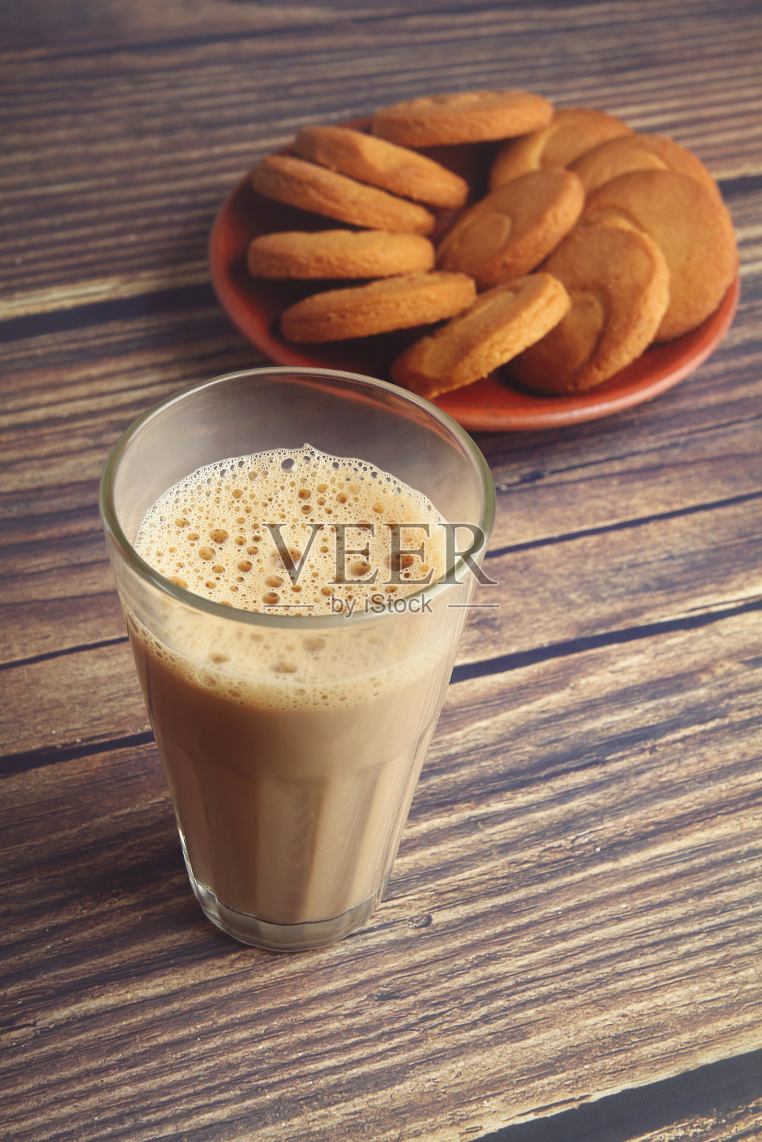 木桌上放着一杯茶和黄油饼干照片摄影图片