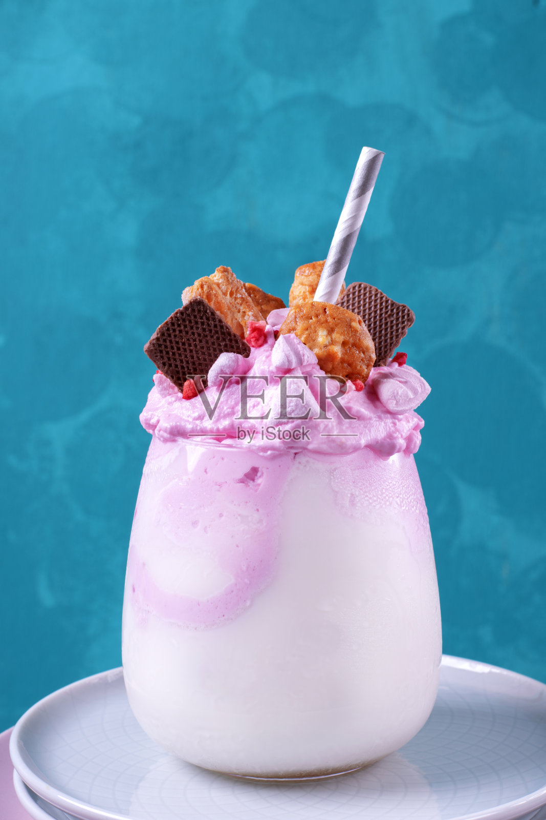 上面有粉红色奶油和各种饼干的奶昔照片摄影图片