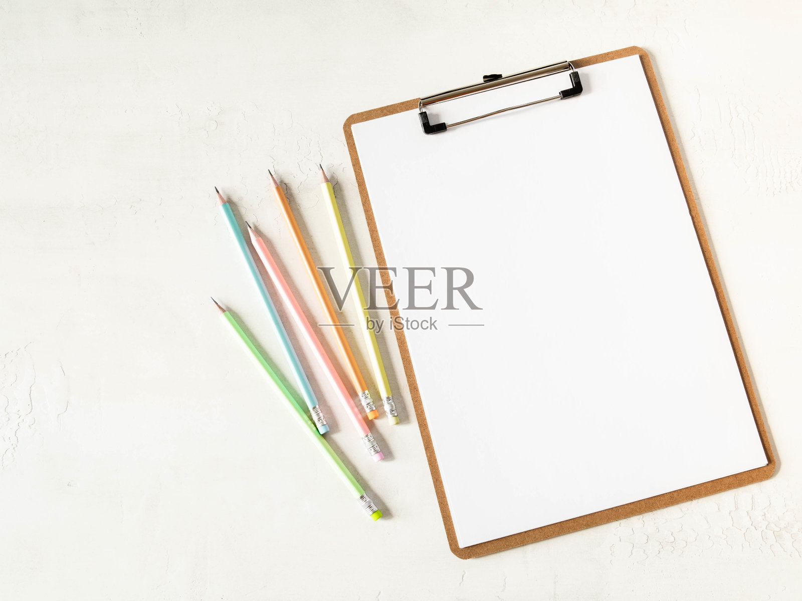 剪贴板与白纸复制空间的文本和多色石墨铅笔在白色的背景。平躺，俯视图女孩工作的经营理念为生活方式博客照片摄影图片