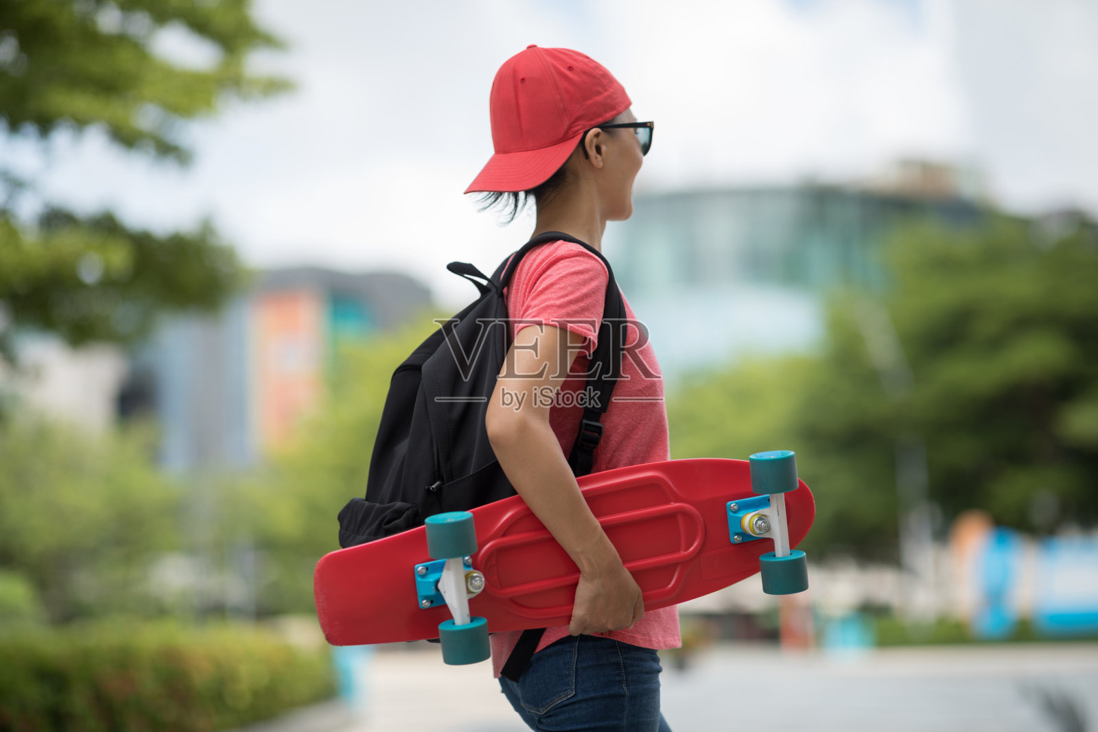 在现代城市里玩滑板的亚洲女人照片摄影图片