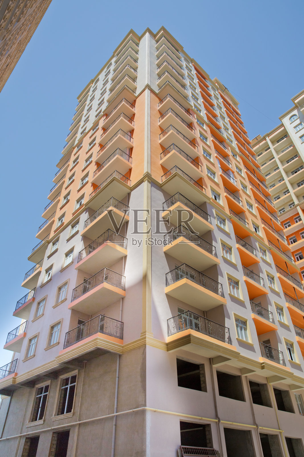 巴库附近的现代多层新住宅橙色建筑立面。新公寓。多层现代住宅。蓝天下的高楼大厦照片摄影图片