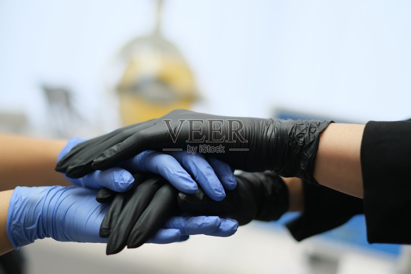 双手在黑色和蓝色乳胶手套在牙科诊所背景照片摄影图片