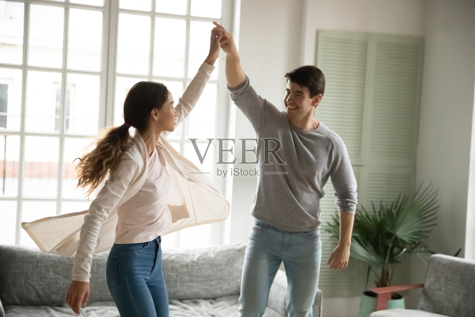 快乐的白人情侣在客厅跳舞照片摄影图片