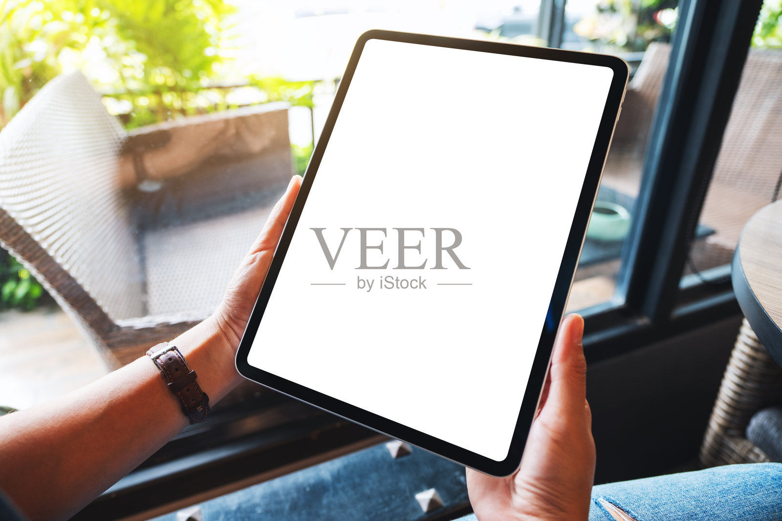 一个女人拿着黑色平板电脑和空白的白色桌面屏幕照片摄影图片